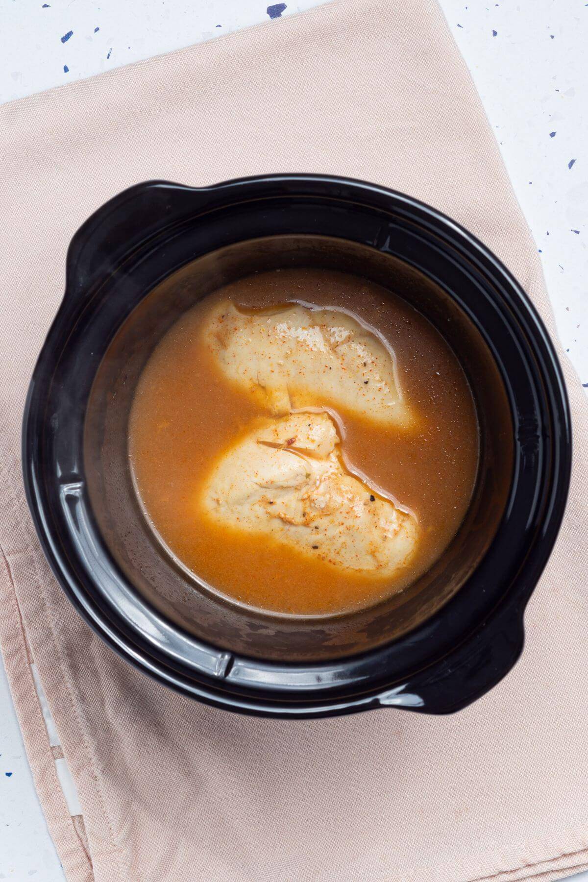 Chicken breasts in a slow cooker with taco seasoning blend.