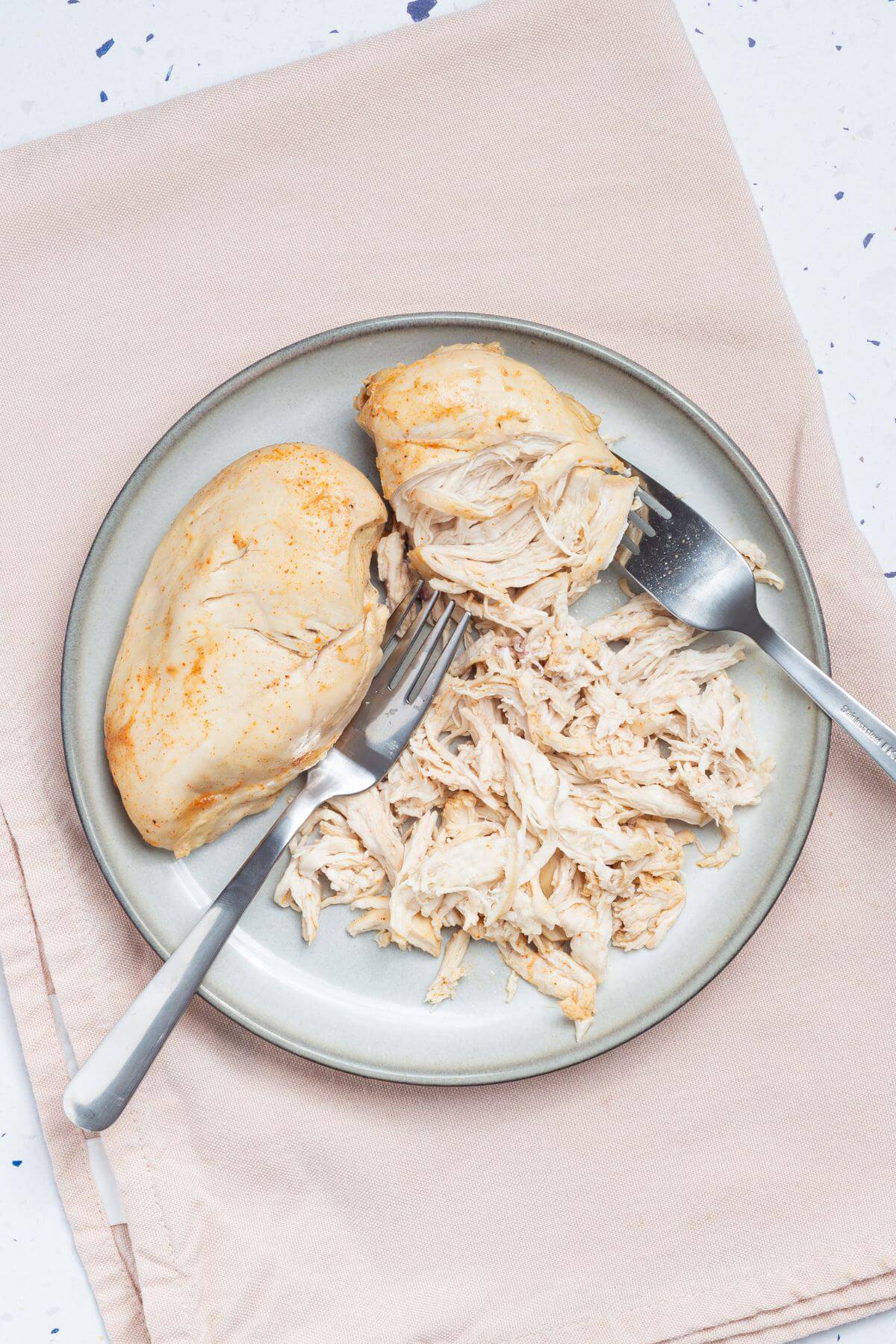 Shredded chicken on a plate with forks.