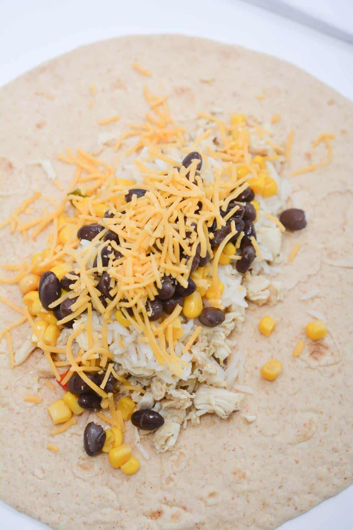 A tortilla with black beans, corn and cheese.