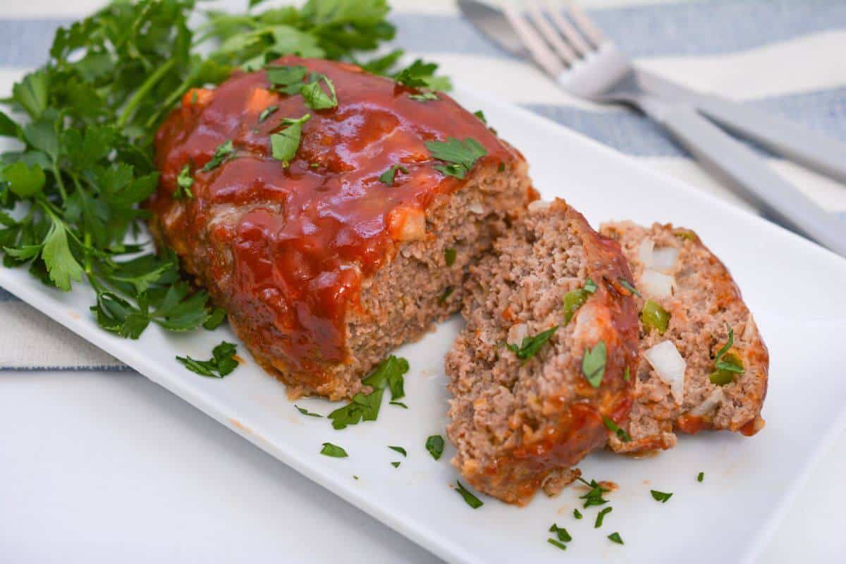 Meatloaf on a white platter with a fork.