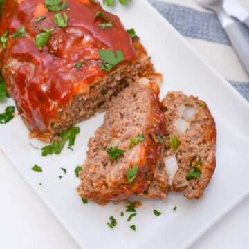 A sliced meatloaf on a white plate.