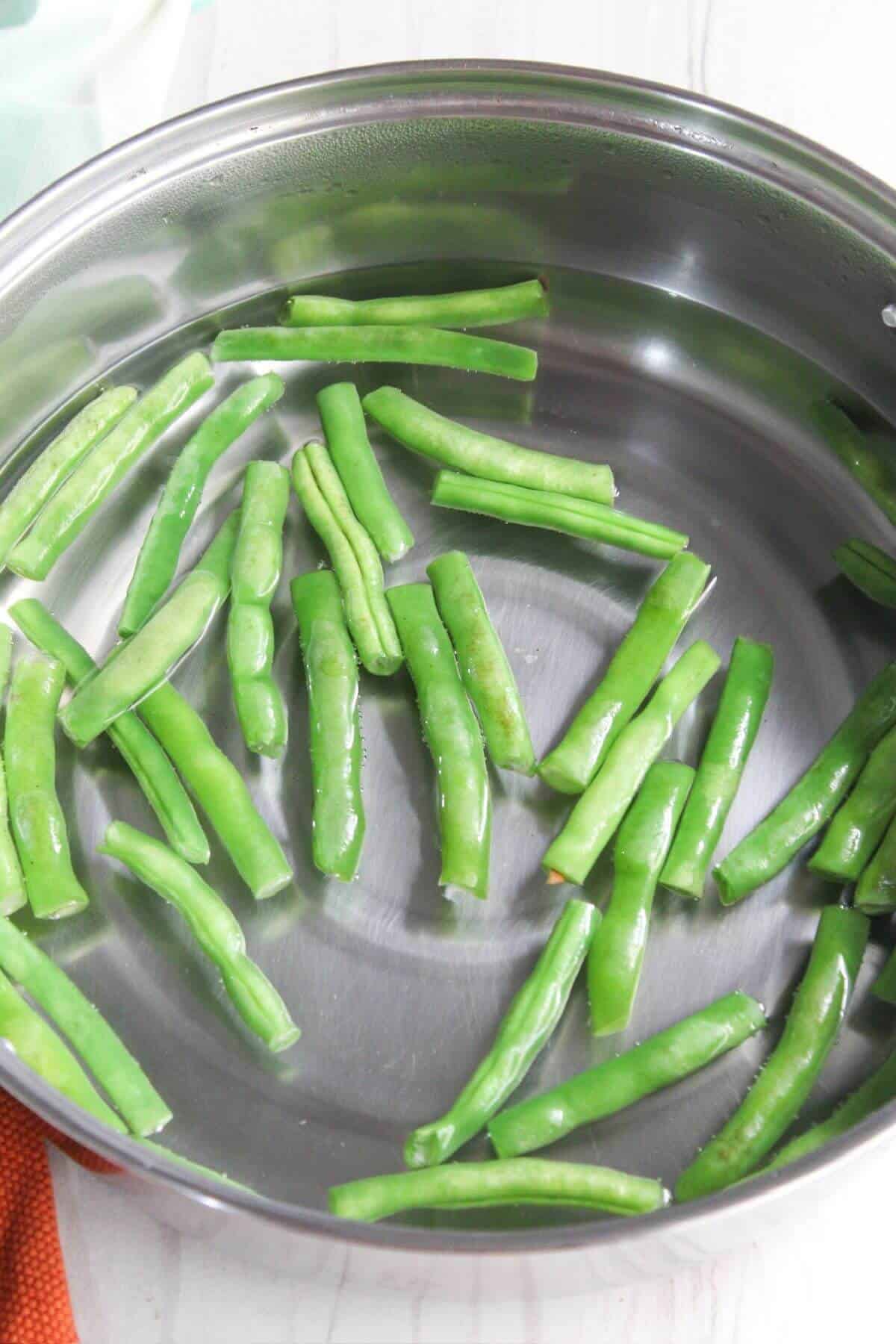 Green beans in a stainless steel pan.