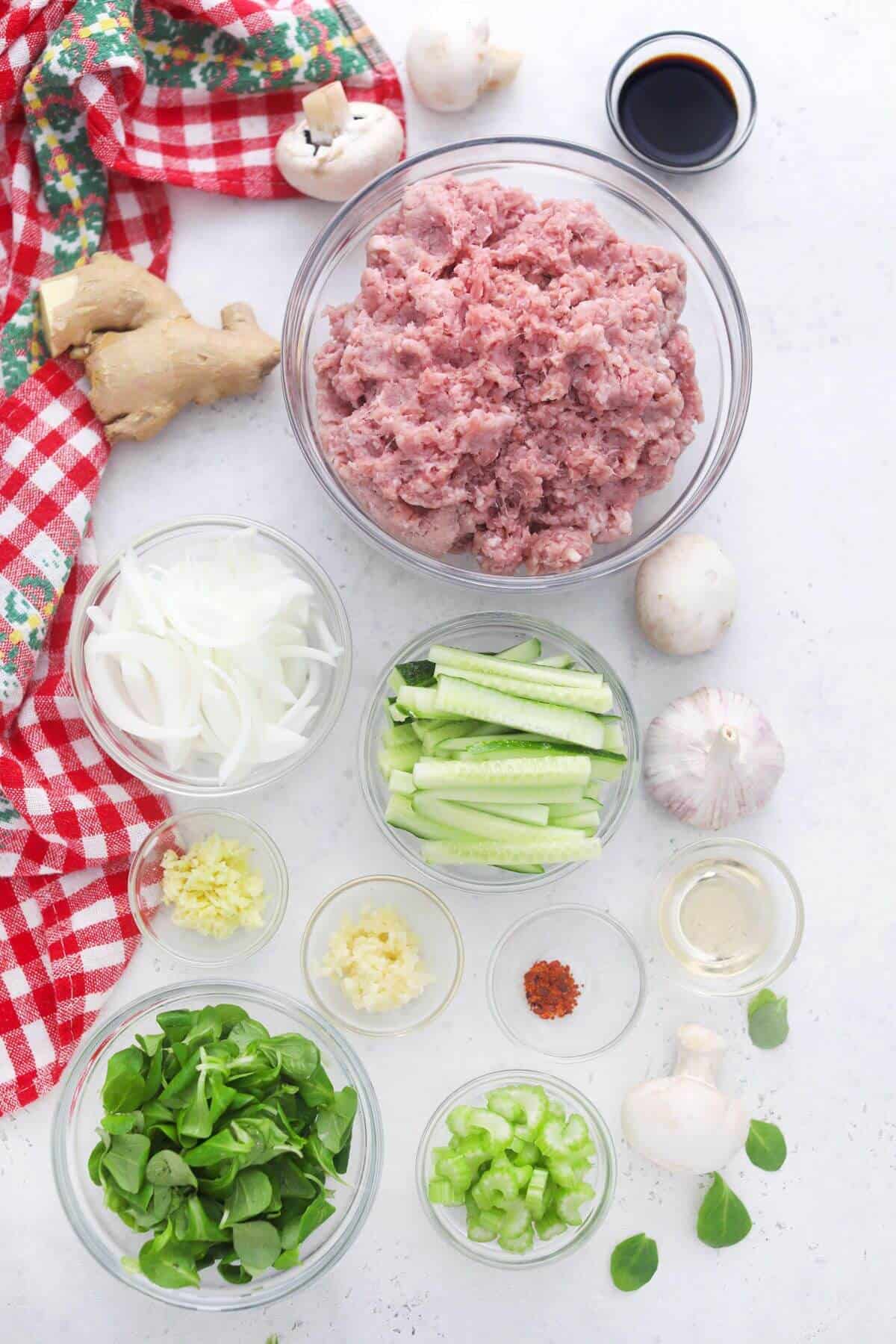 Ingredients for ground pork stir fry on a white background.