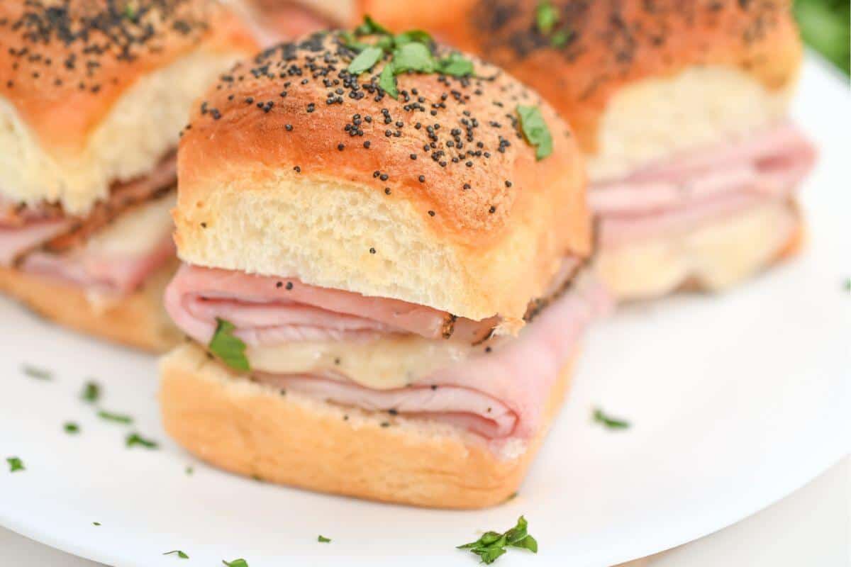 Ham and cheese sliders on a plate.