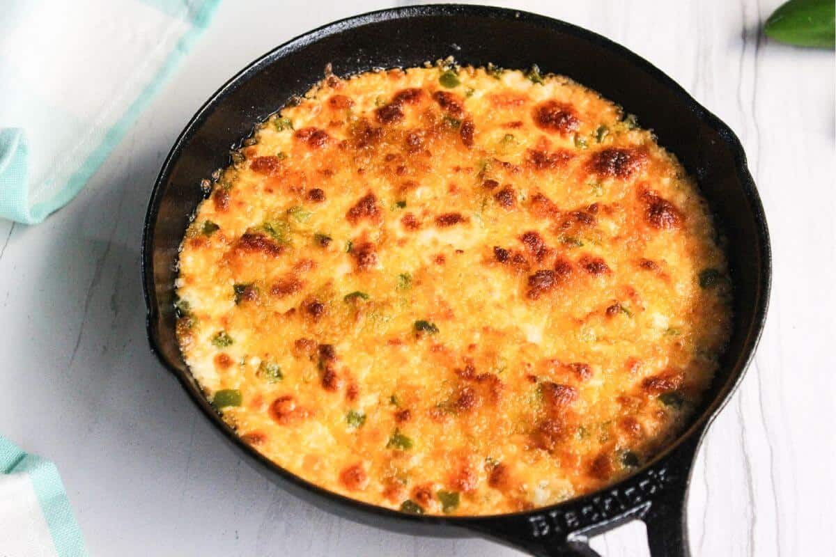 A cast iron skillet filled with a cheesy dip.