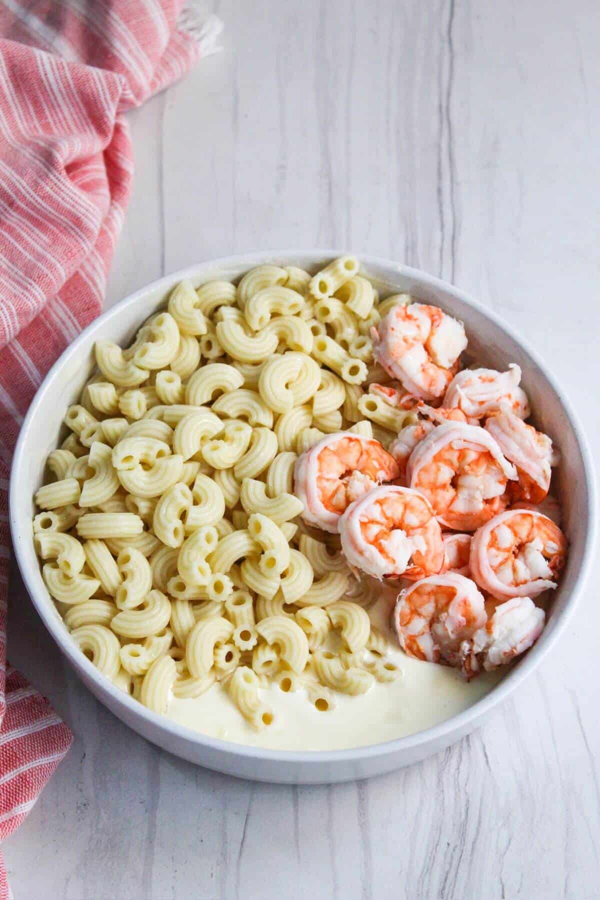 Macaroni and shrimp in a white bowl.