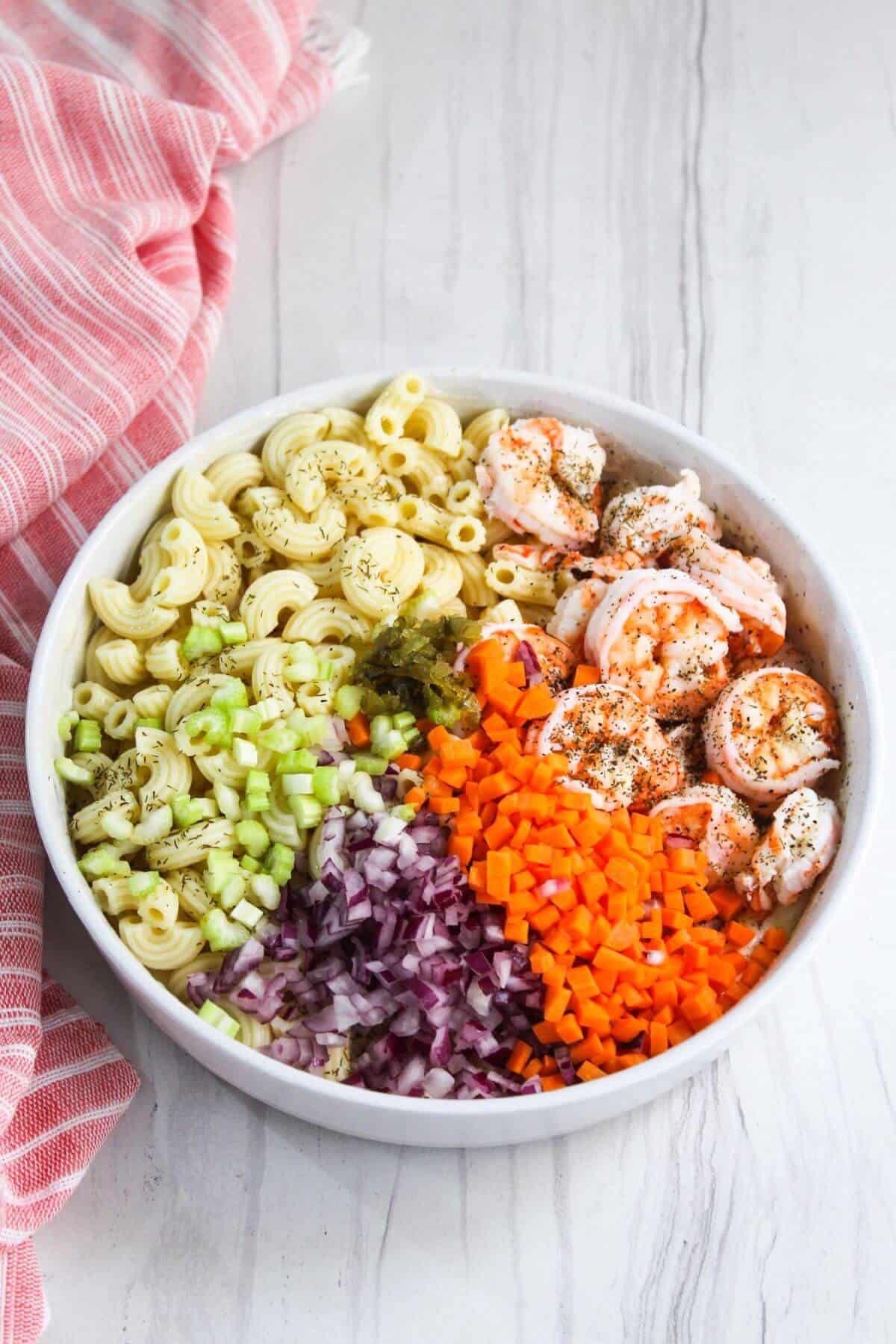 Shrimp pasta salad in a white bowl.