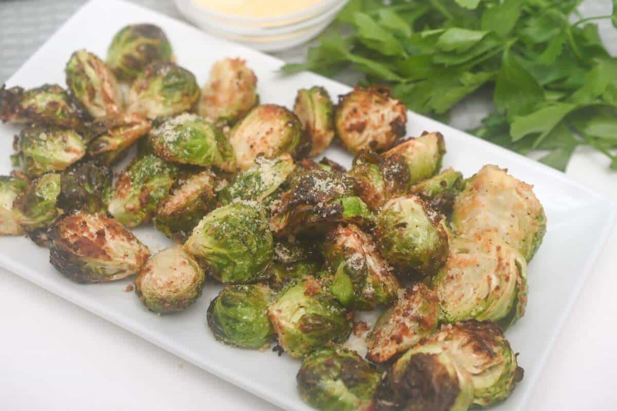 Roasted air fryer brussels sprouts on a white plate.