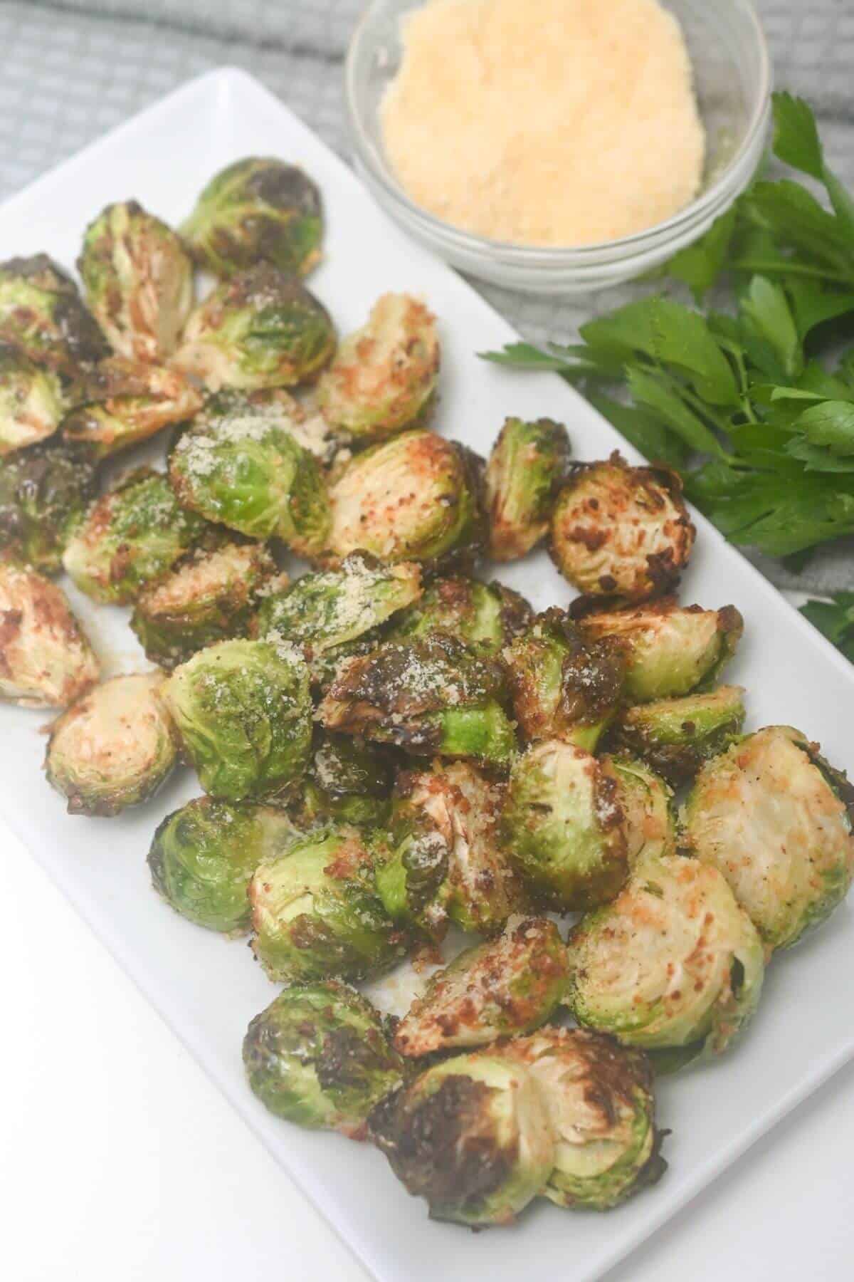 Air fryer brussels sprouts on a white plate with parmesan.