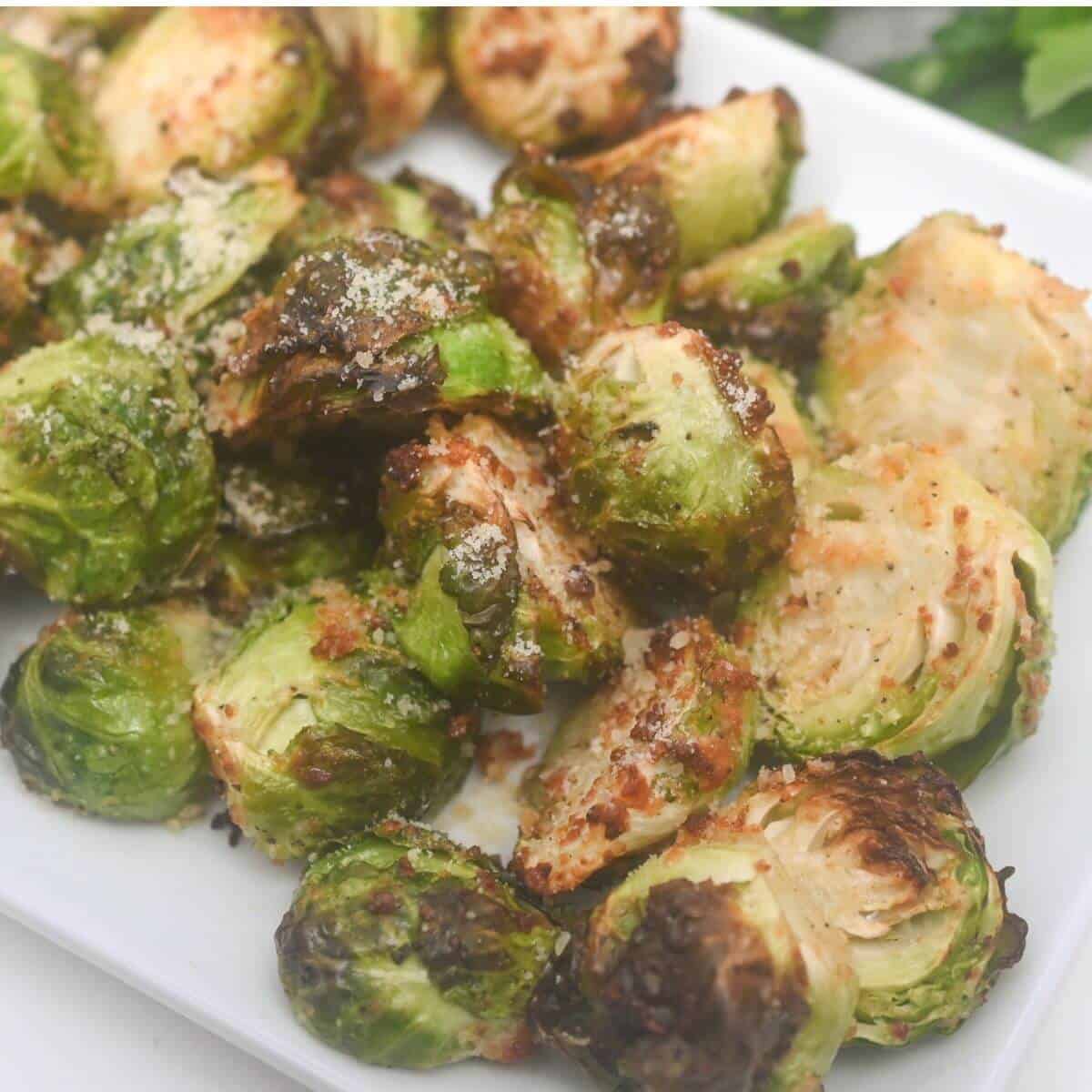 Roasted air fryer brussels sprouts on a white plate.