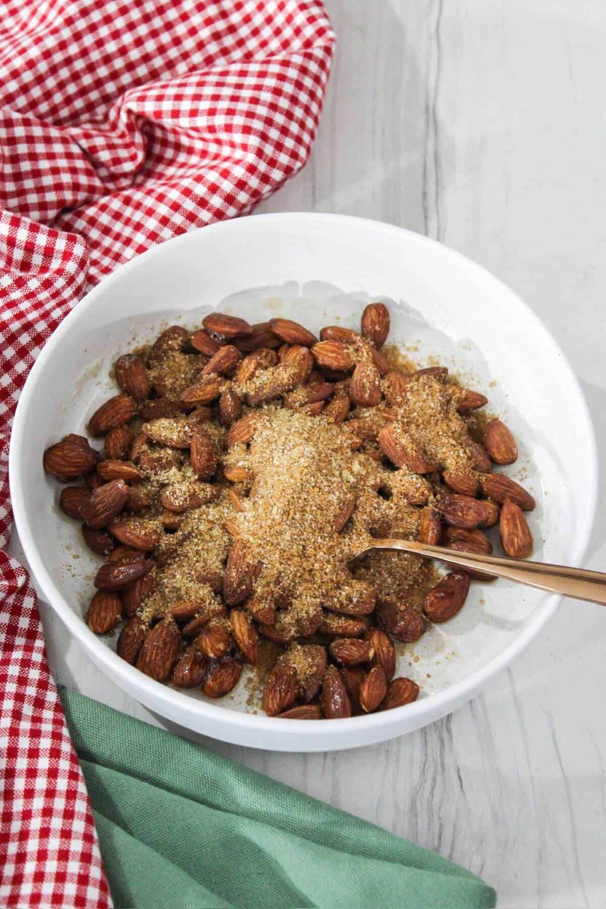 Brown sugar mixture added to coated almonds in boal.