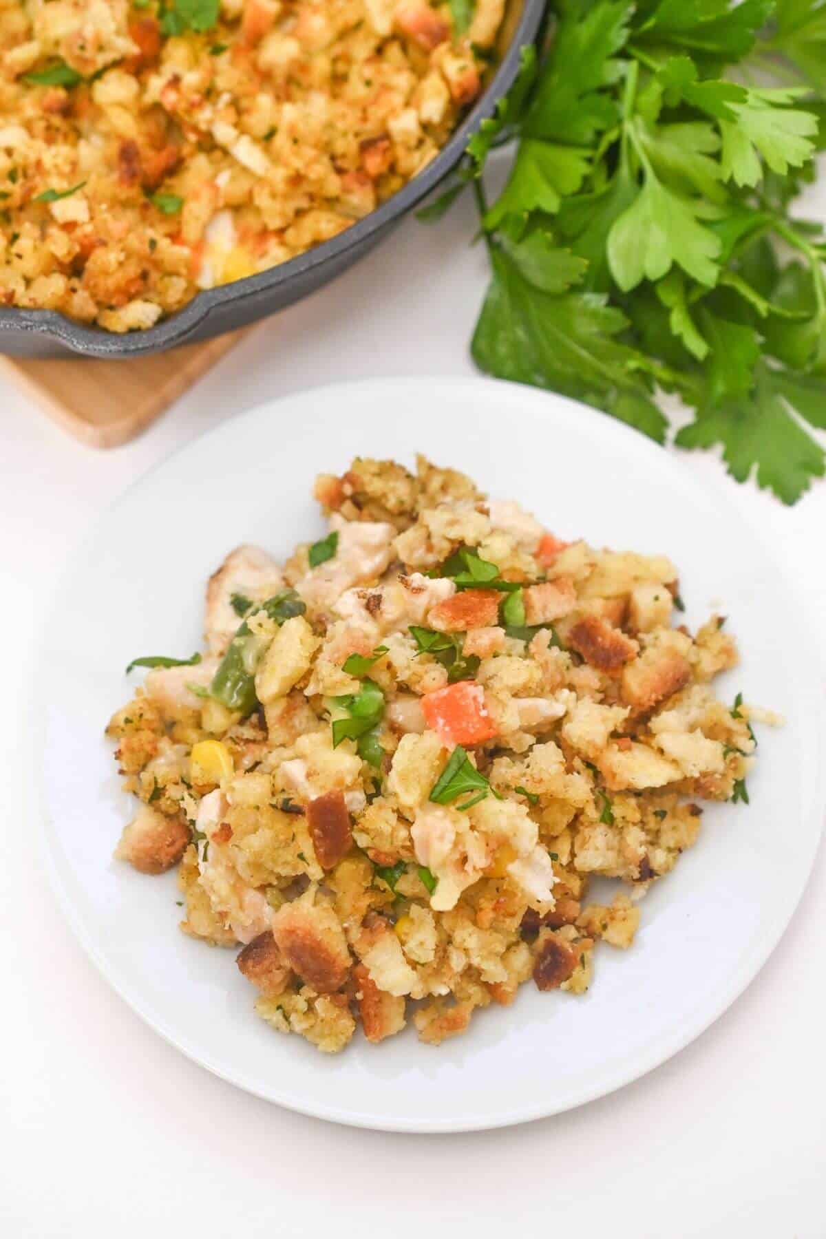Chicken and stuffing on a white plate with parsley.