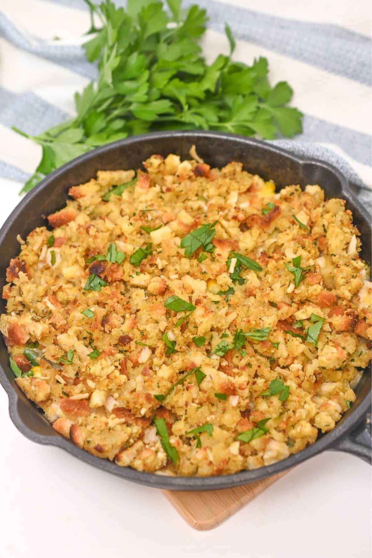 A skillet filled with chicken stuffing and topped with parsley.