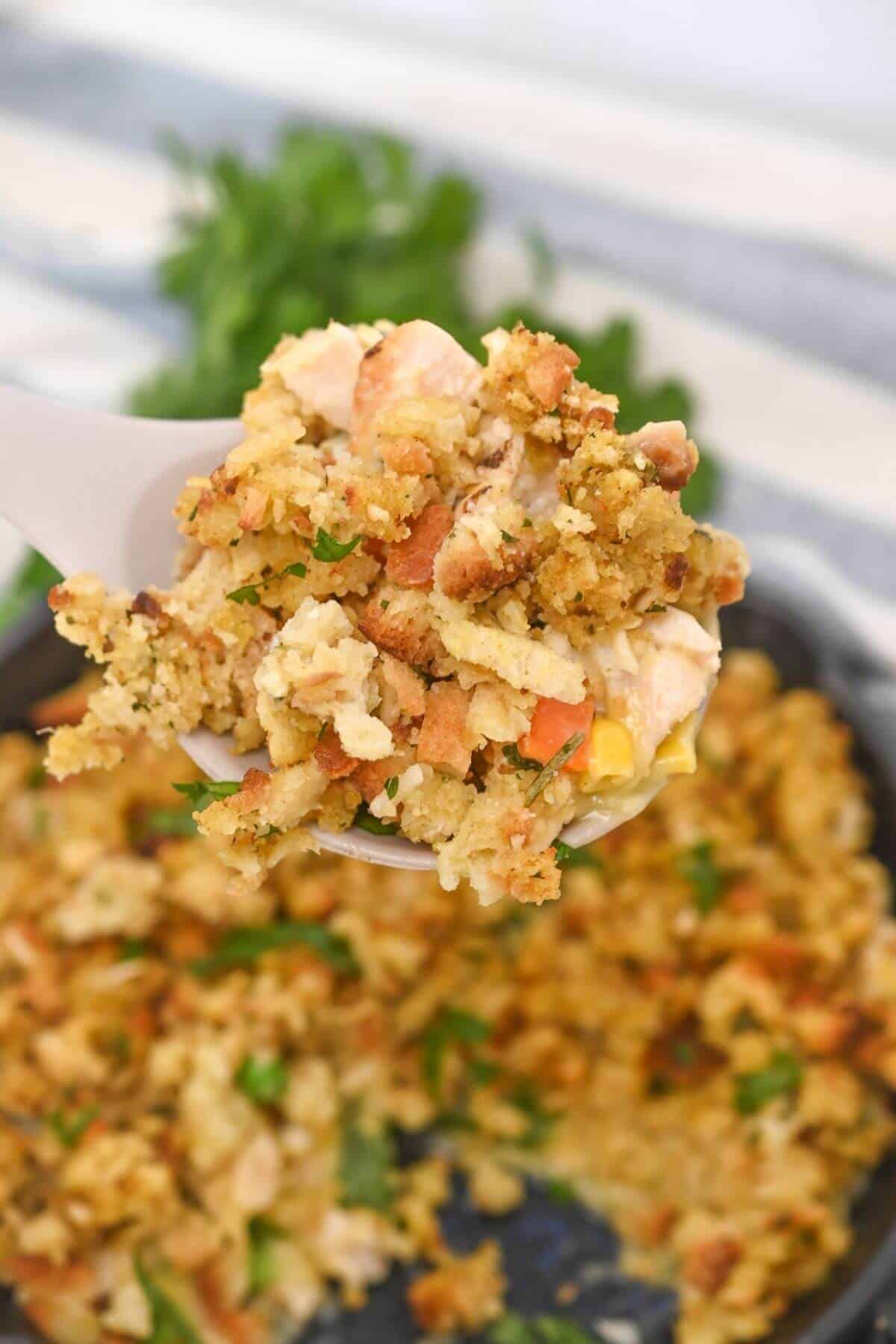 A spoonful of chicken stuffing over a skillet.