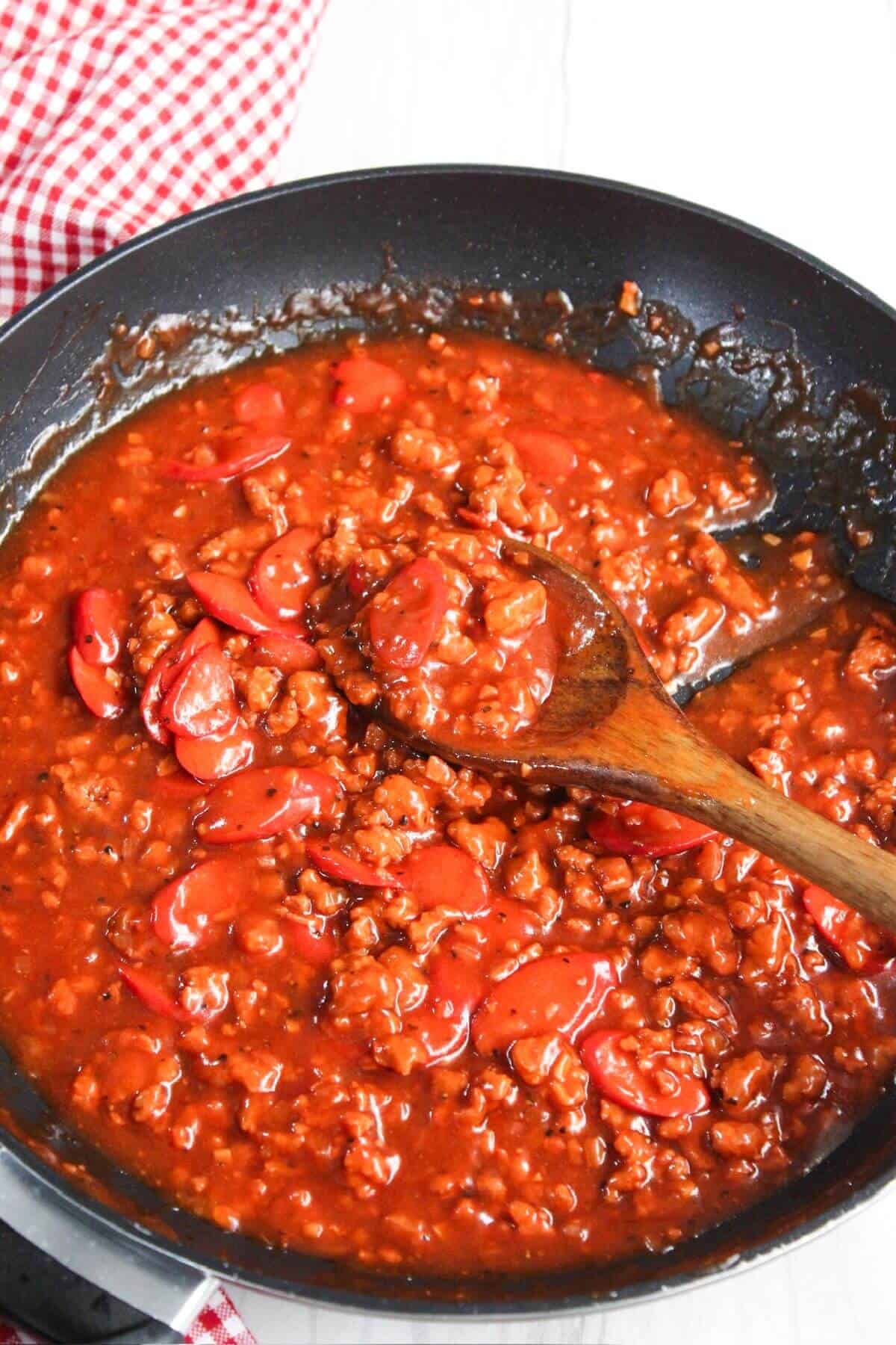 A frying pan filled with ground meat and tomato sauce.