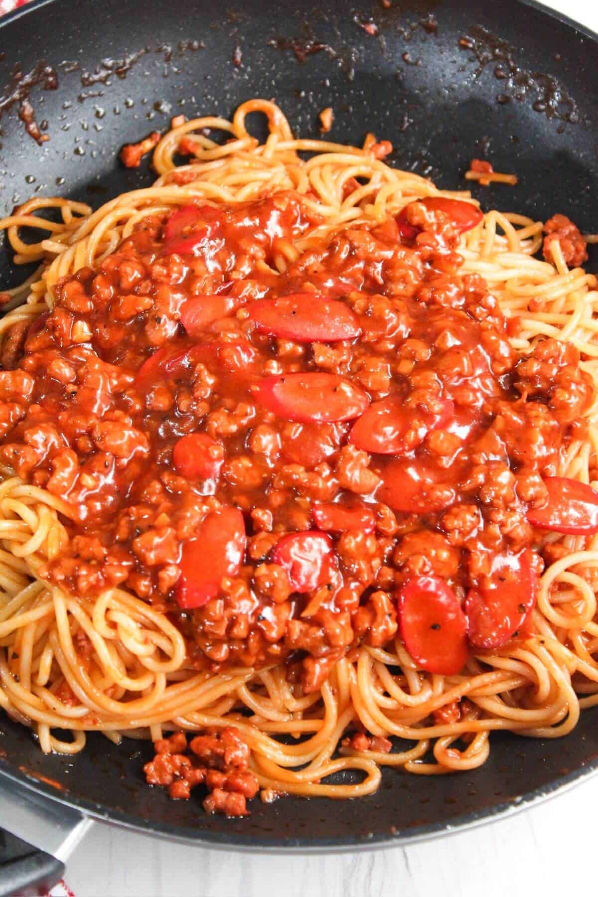 Spaghetti and meat sauce in a frying pan.