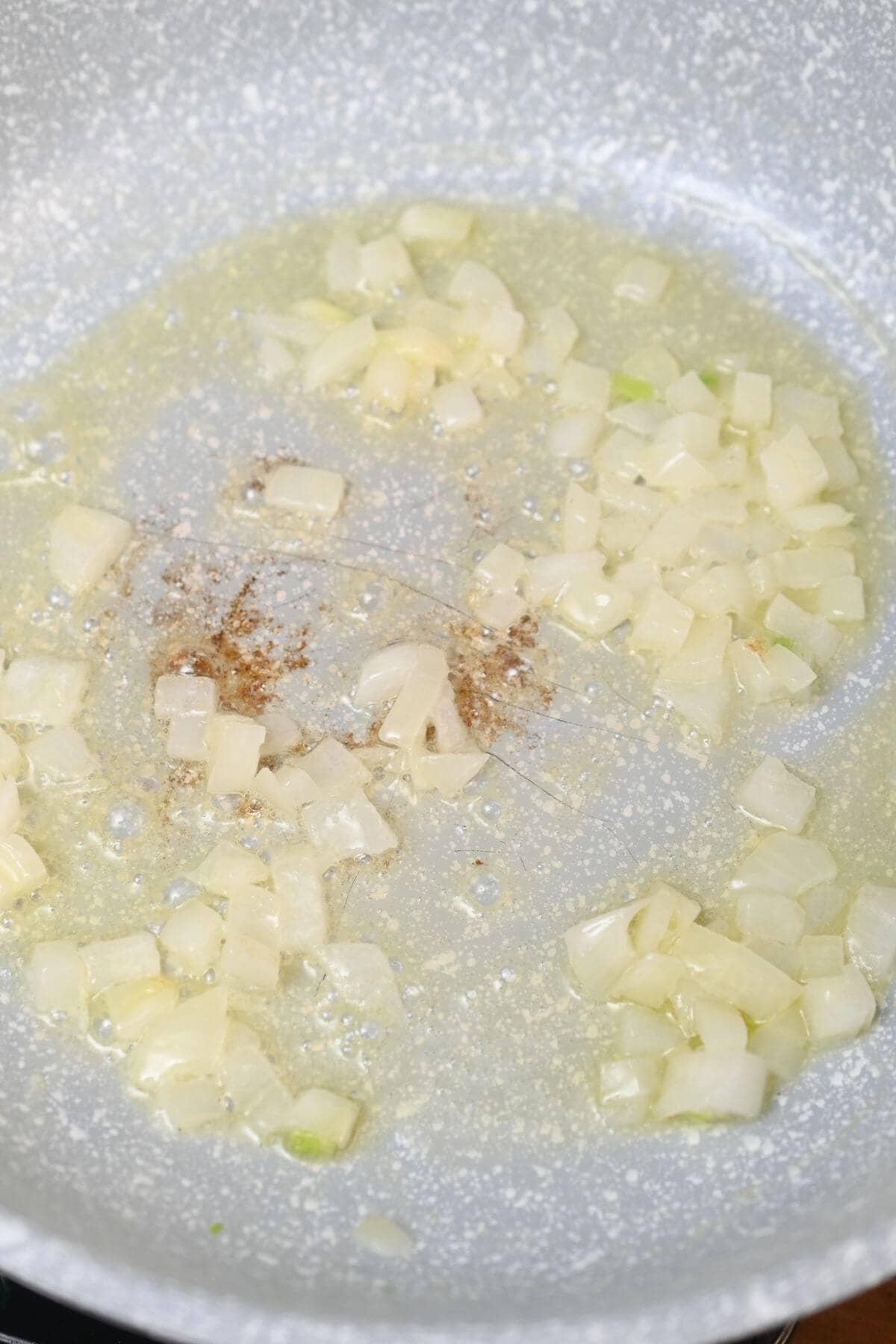 Sauteing onions in a frying pan.