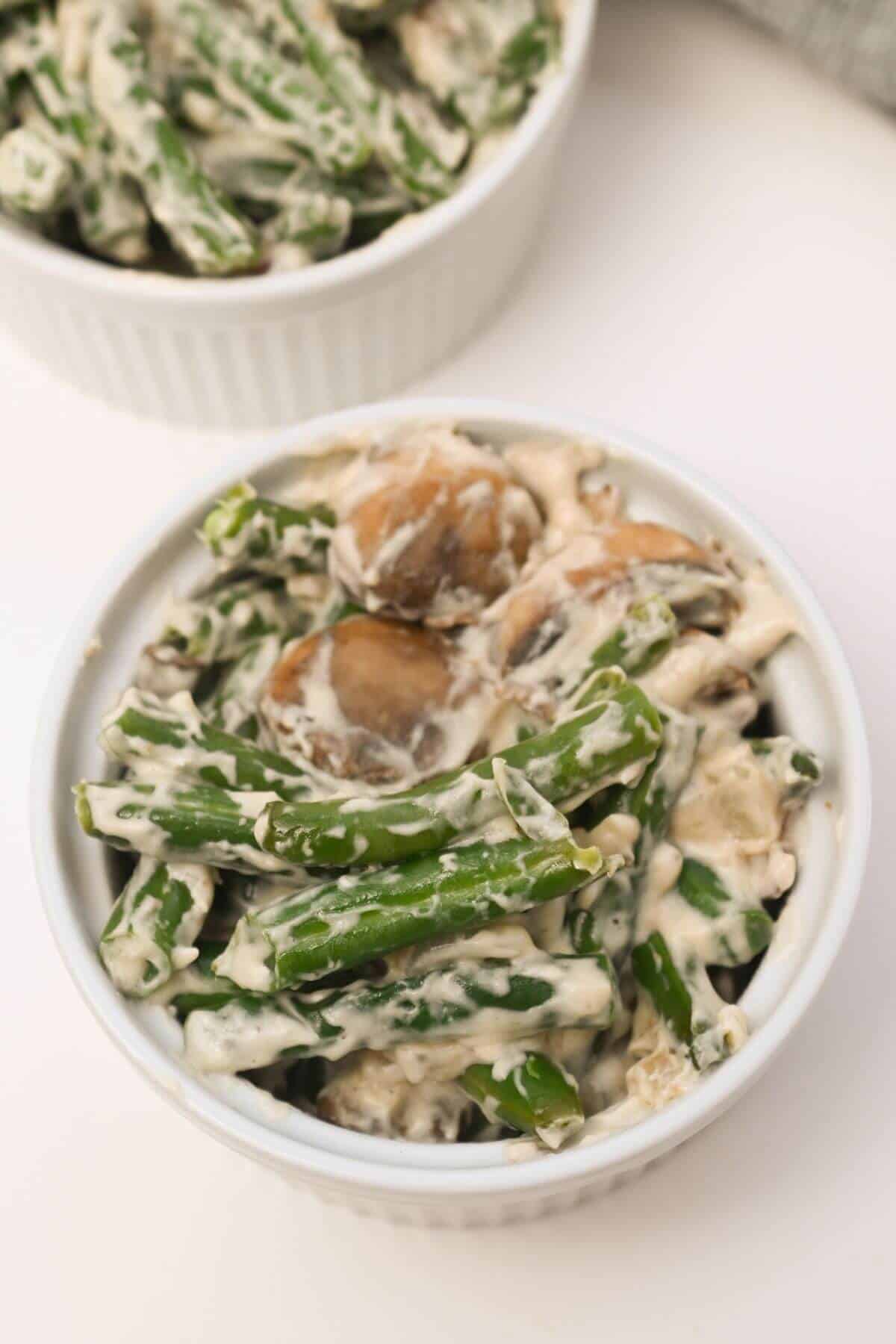 Green beans and mushrooms in a white bowl.