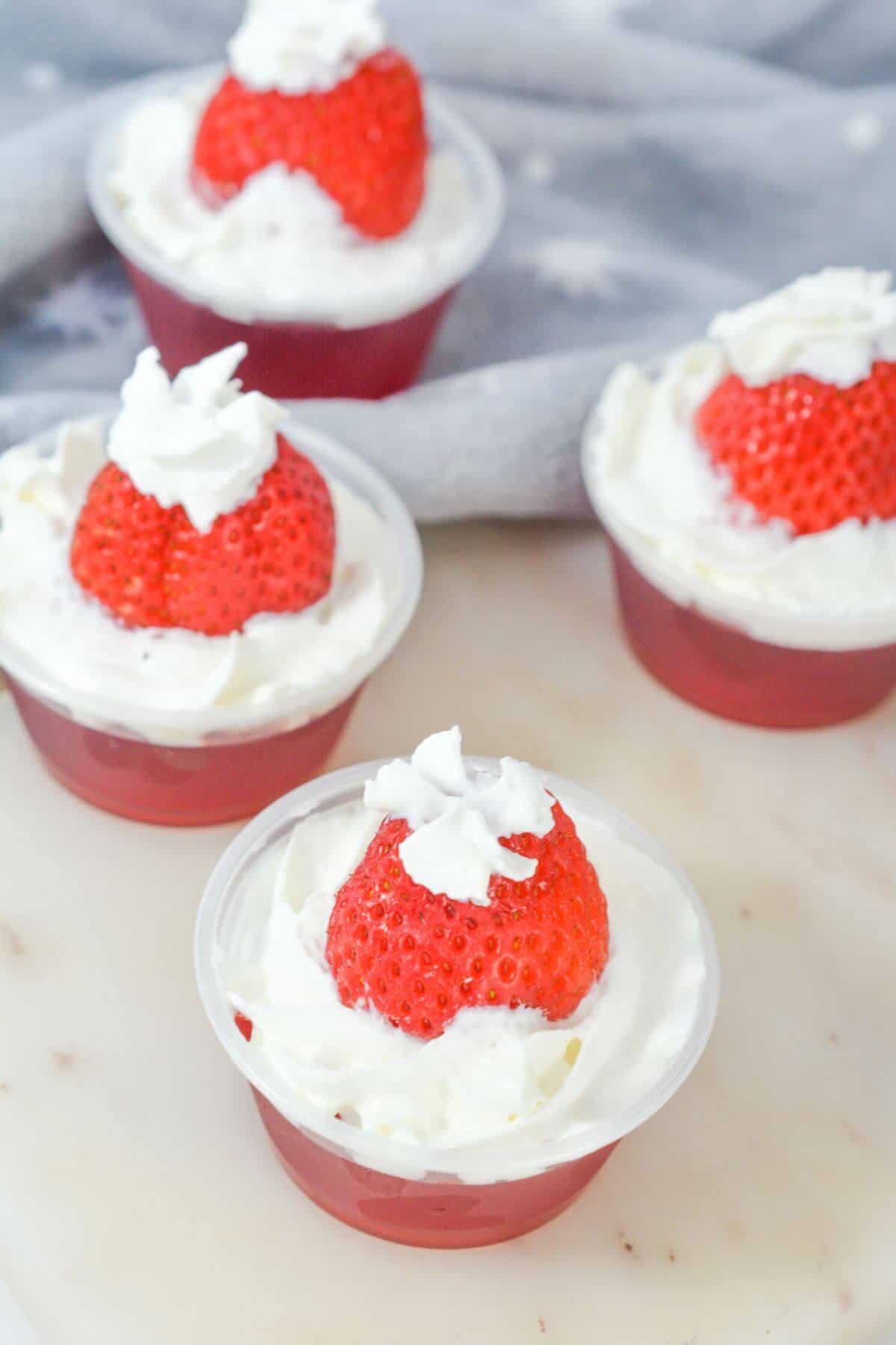 Santa hat jello shots with whipped cream on top.