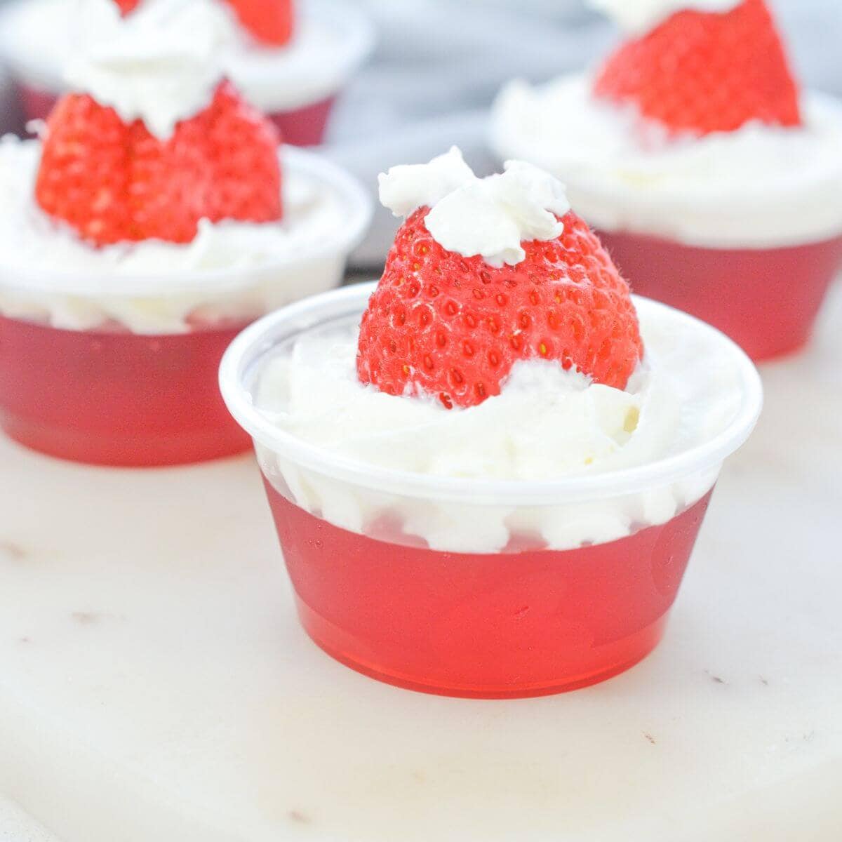 Santa hat jello shots with whipped cream and strawberries.