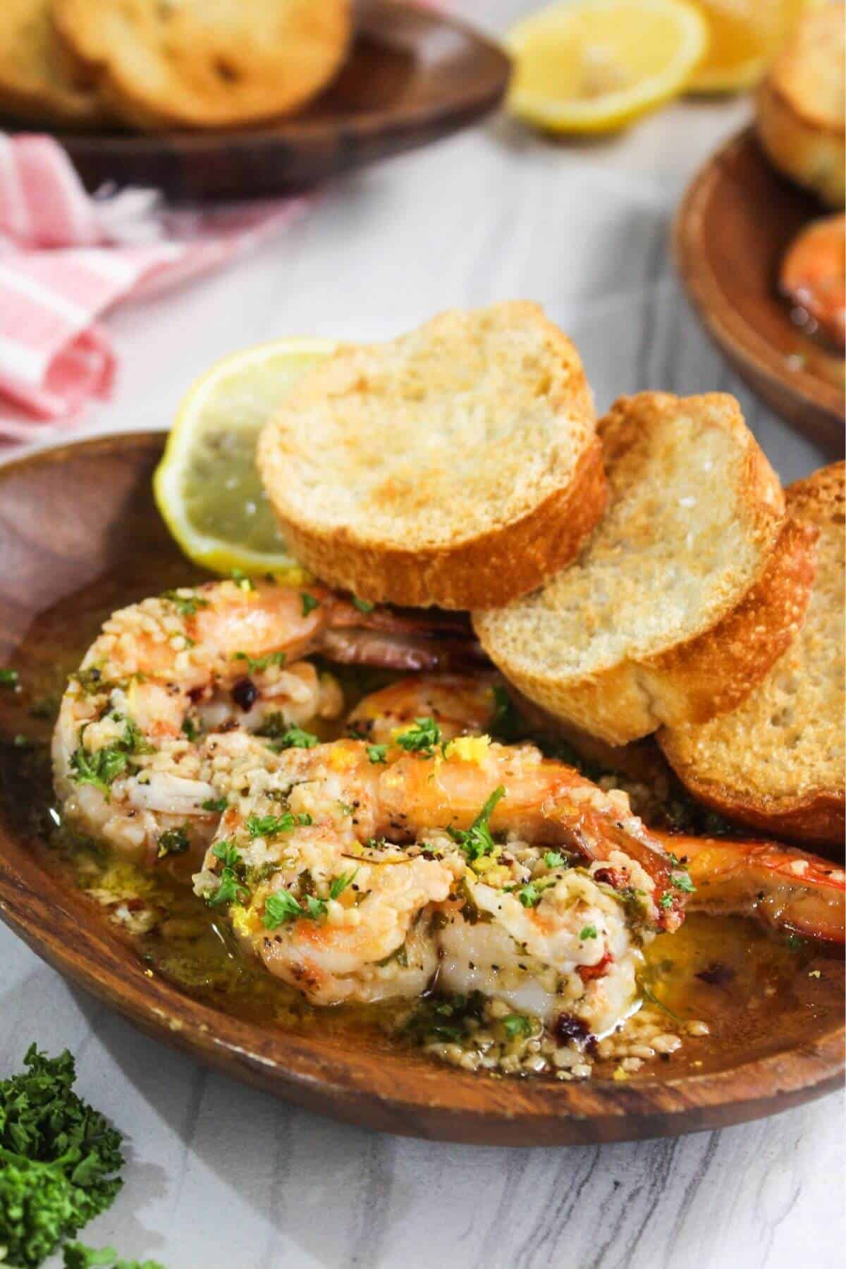 A plate with shrimp scampi and bread on it.