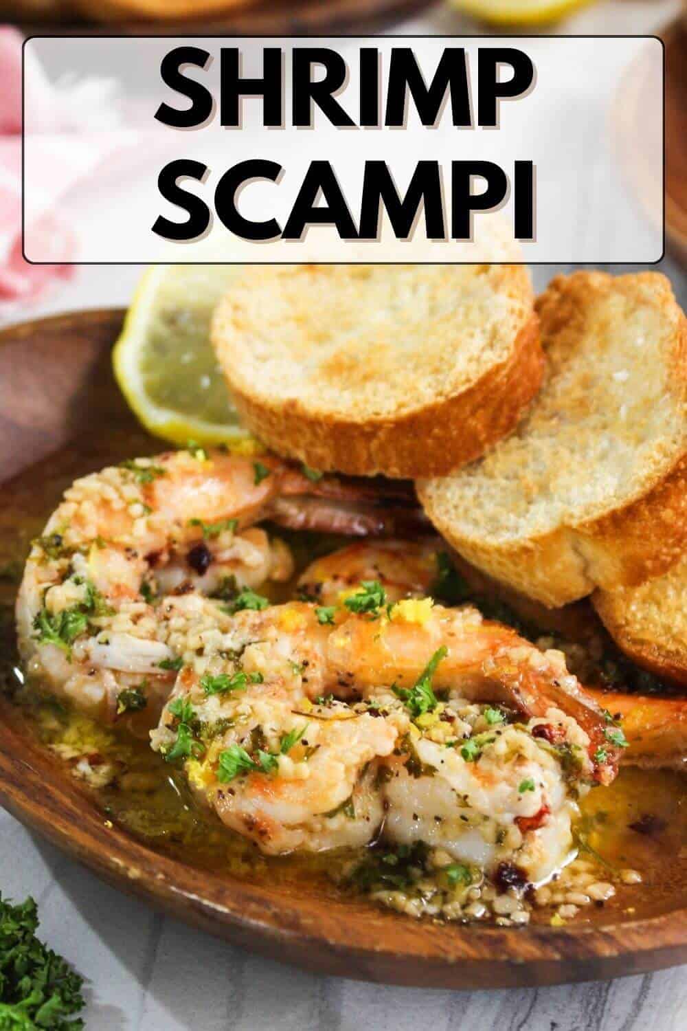 Shrimp scampi on a plate with bread and lemon.