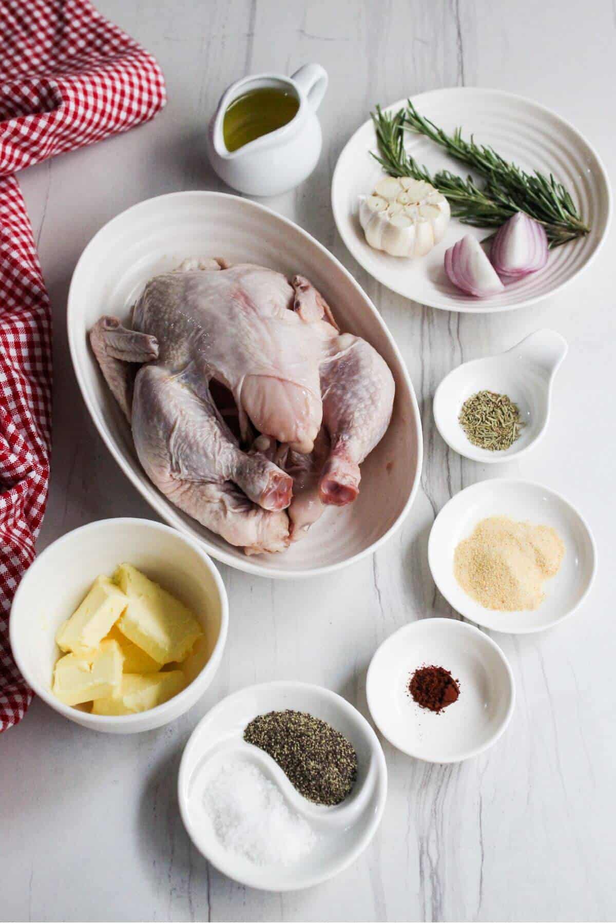 Ingredients for whole chicken in an air fryer on a white table.
