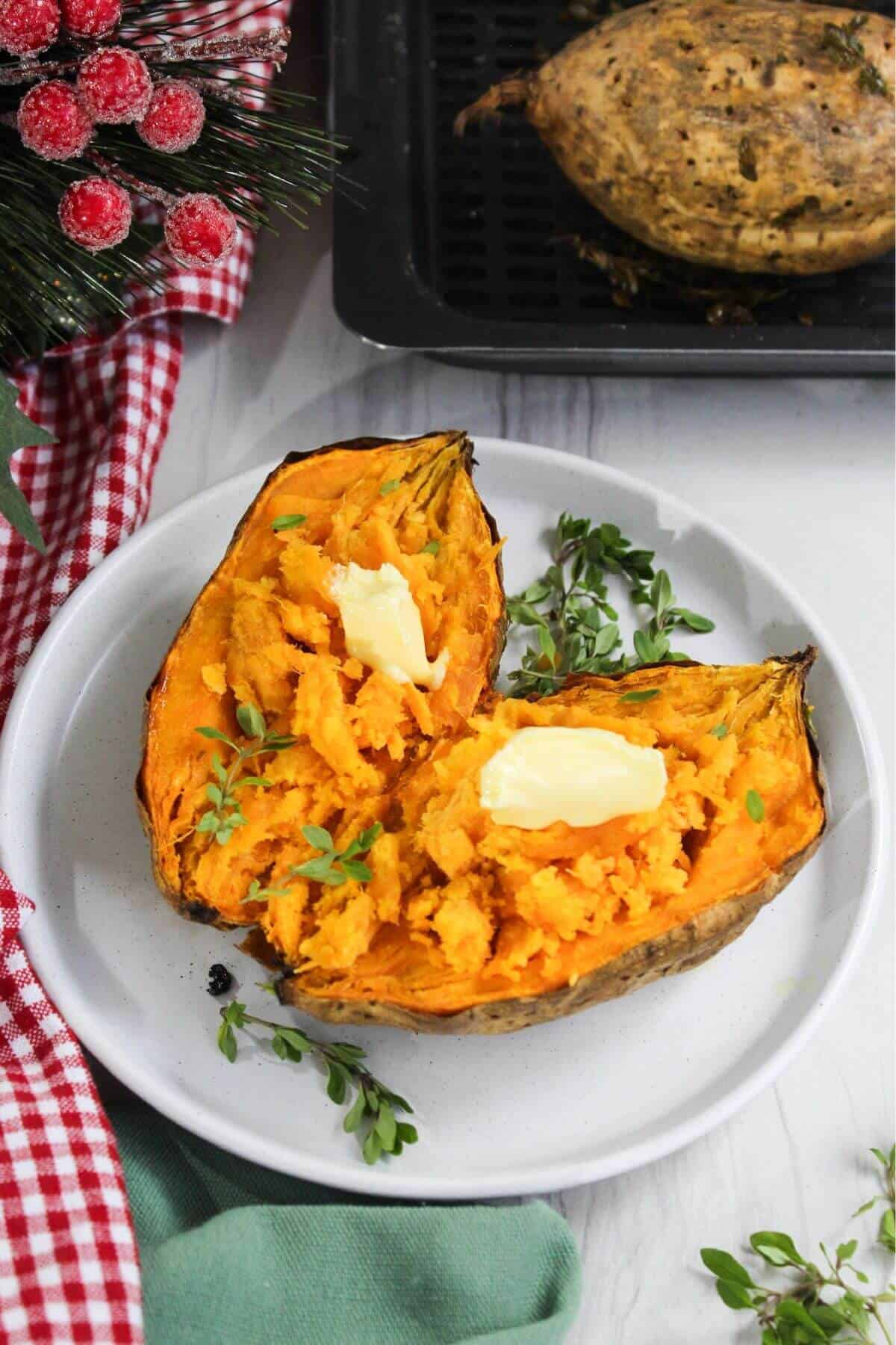 Stuffed sweet potatoes on a plate with butter and herbs.