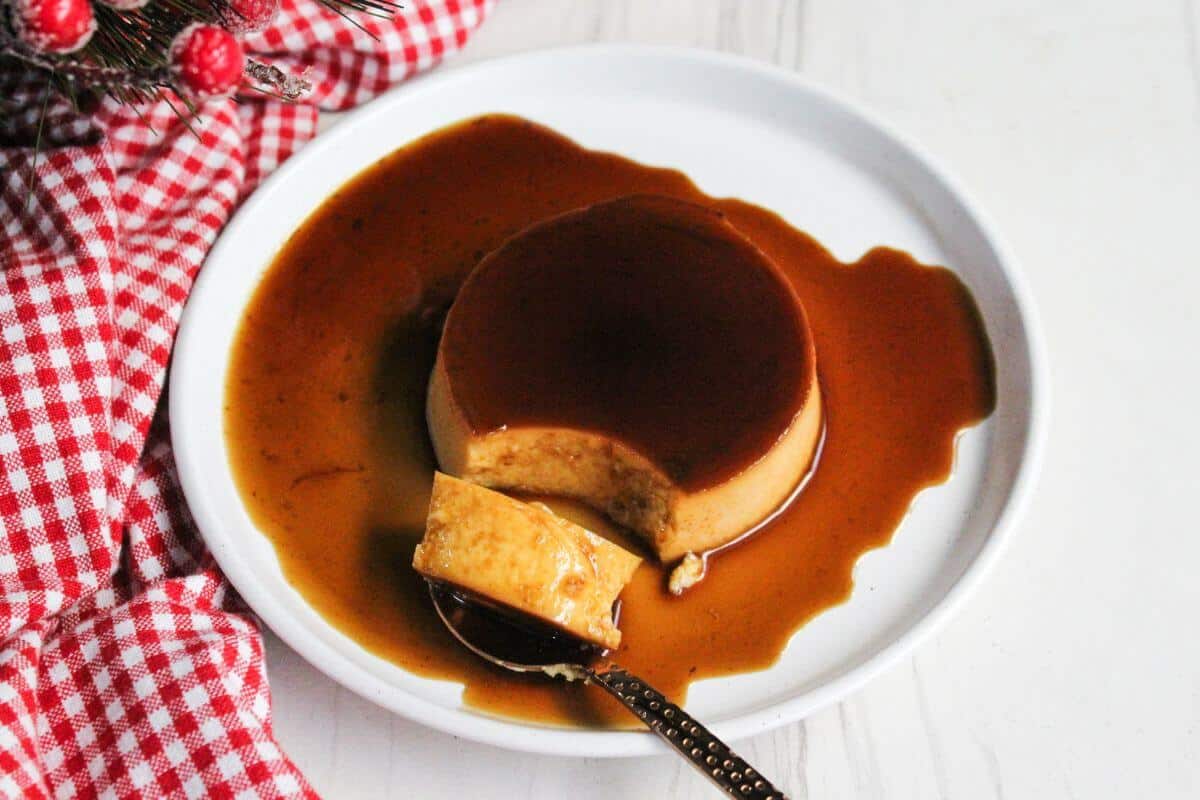 Leche flan served on a plate with a spoon.