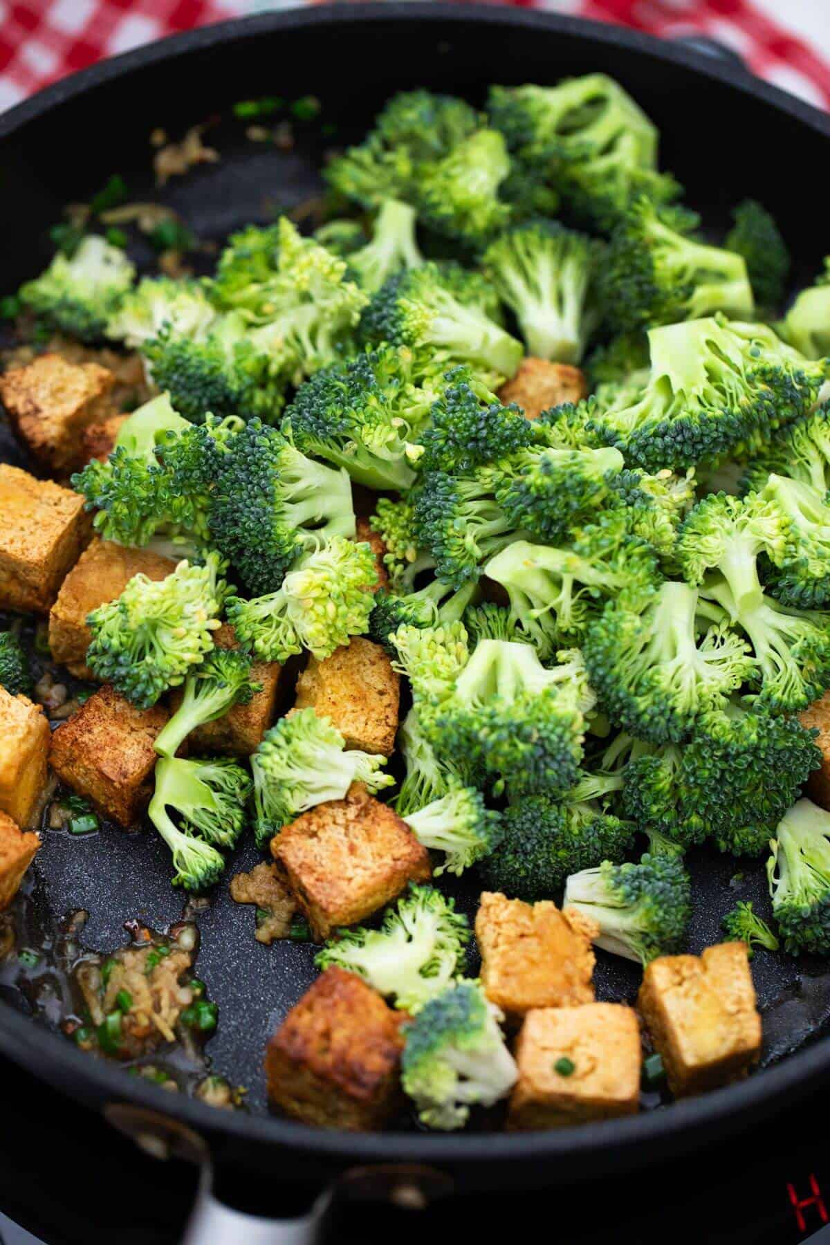 A pan with broccoli and tofu in it.