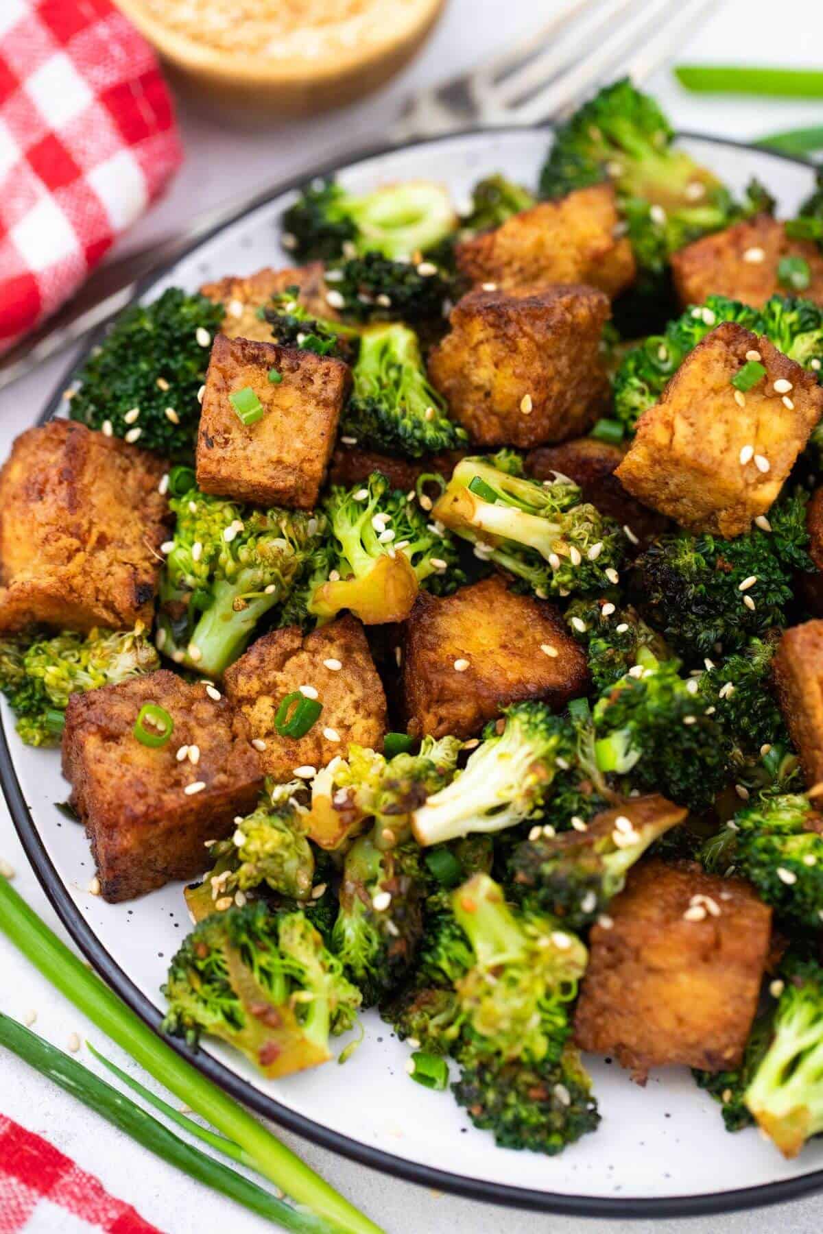 Tofu and broccoli on a plate.