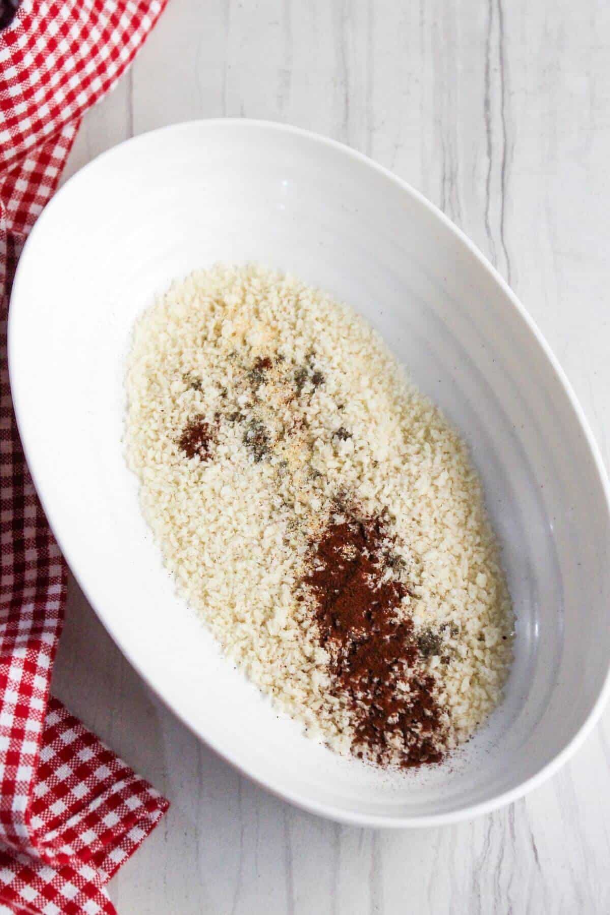 Panko with seasonings in a white bowl with a red and white checkered napkin.