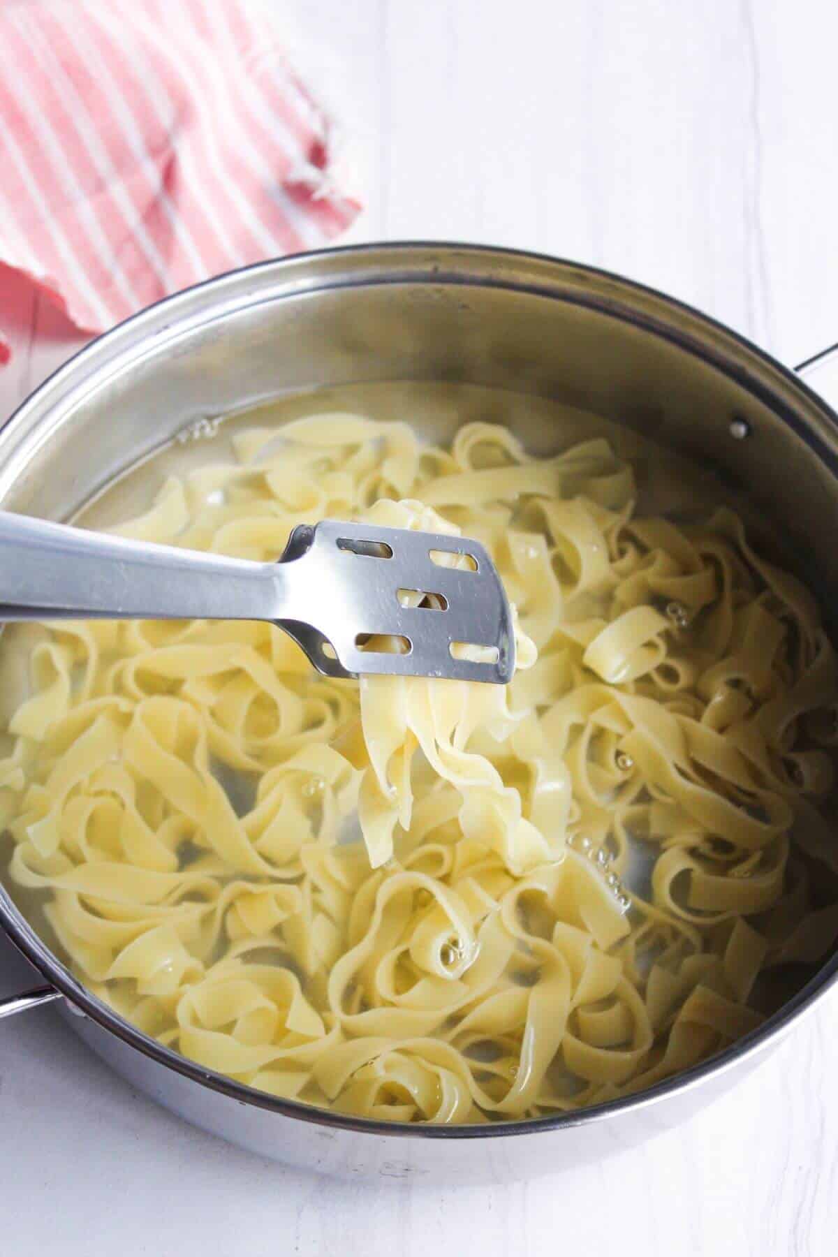 A pot of noodles with a spatula.