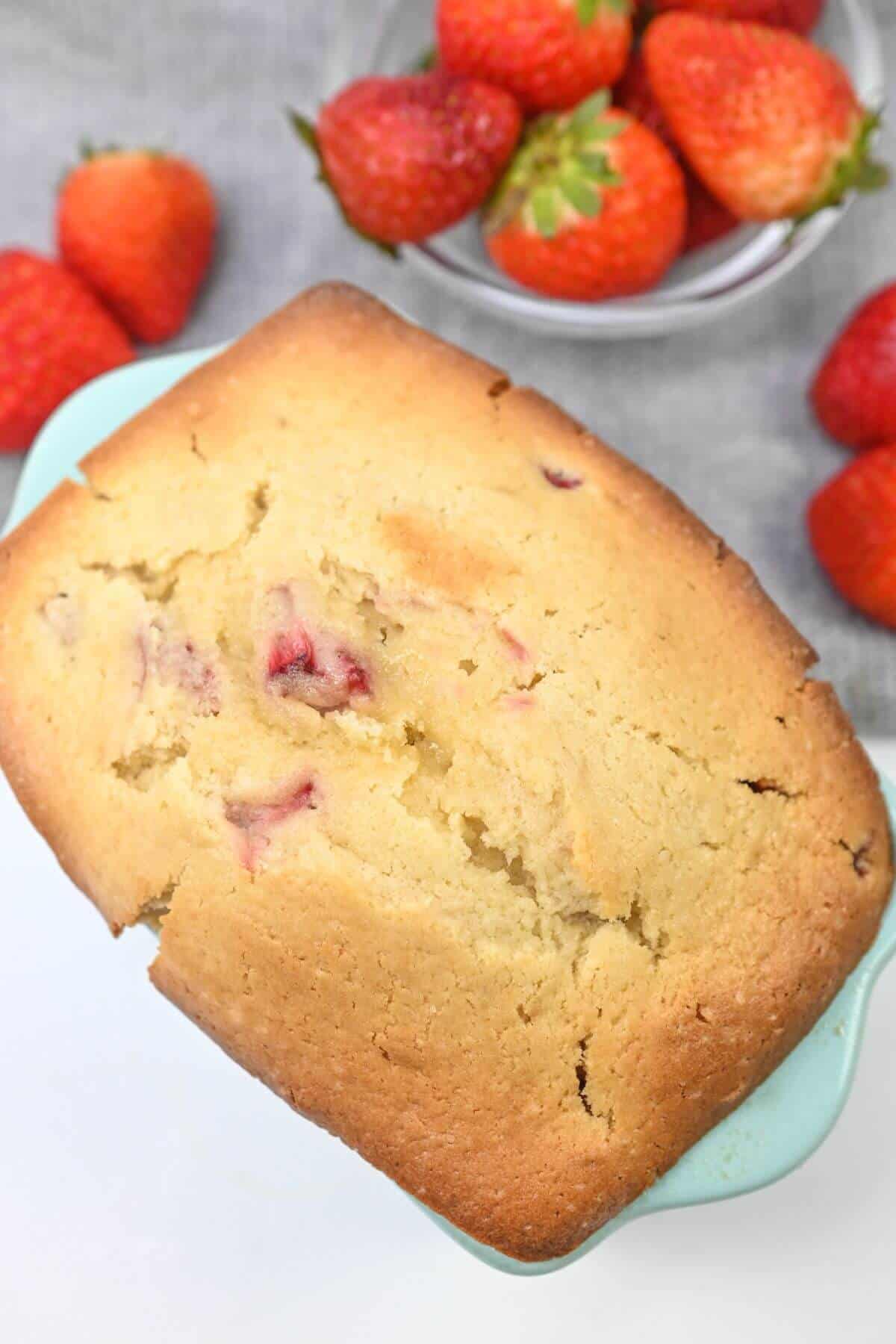 A loaf of strawberry pound cake in a loaf pan.