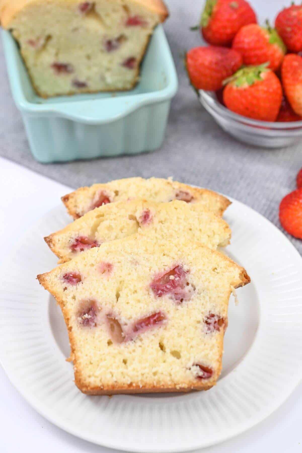 Strawberry pound cake slices with fresh strawberries served on a plate.