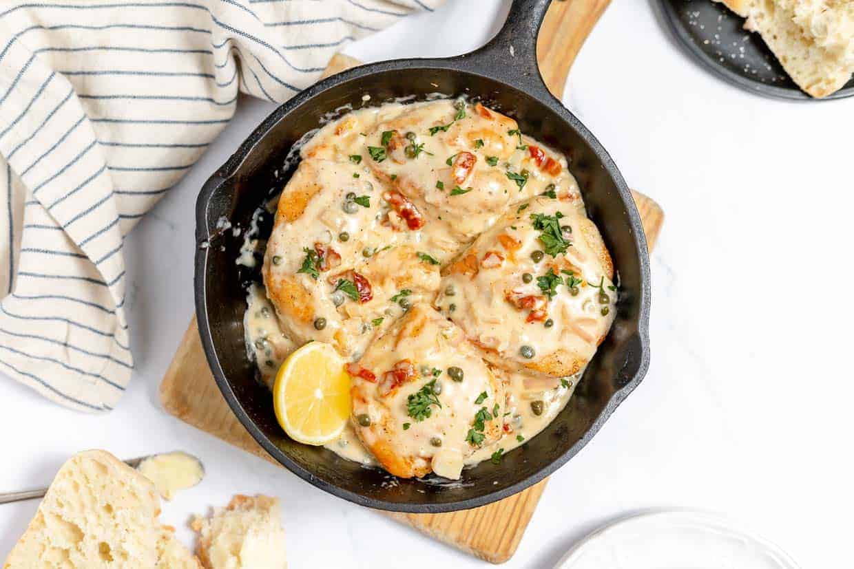 Creamy chicken in a cast iron skillet with capers.