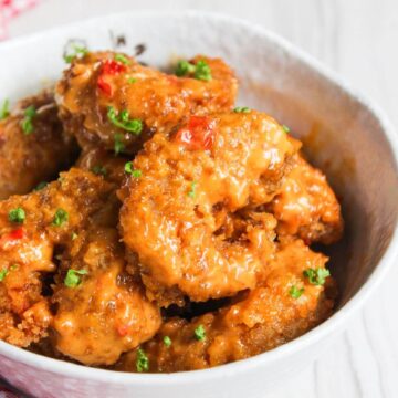 Fried shrimp in a white bowl with sauce.