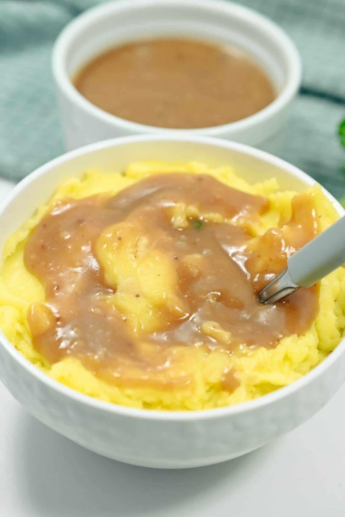 Gravy poured over mashed potatoes.