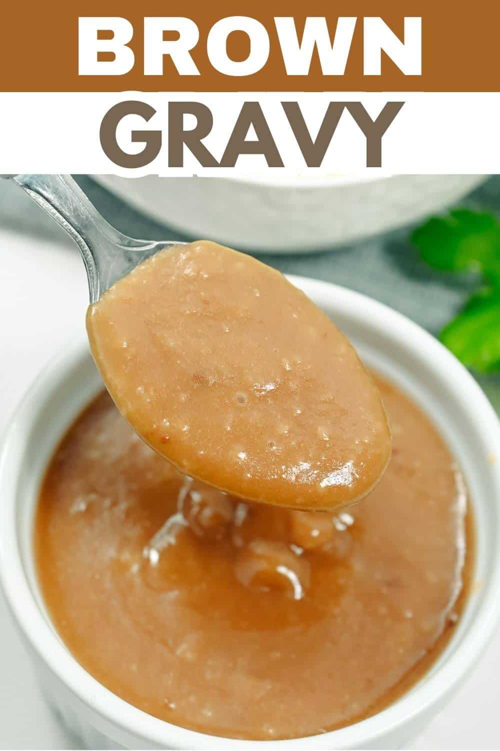 A bowl of brown gravy, accompanied by a spoon.
