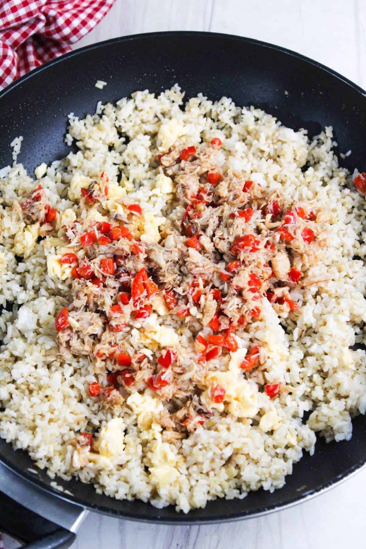 Fried rice with crab meat and peppers in a frying pan.