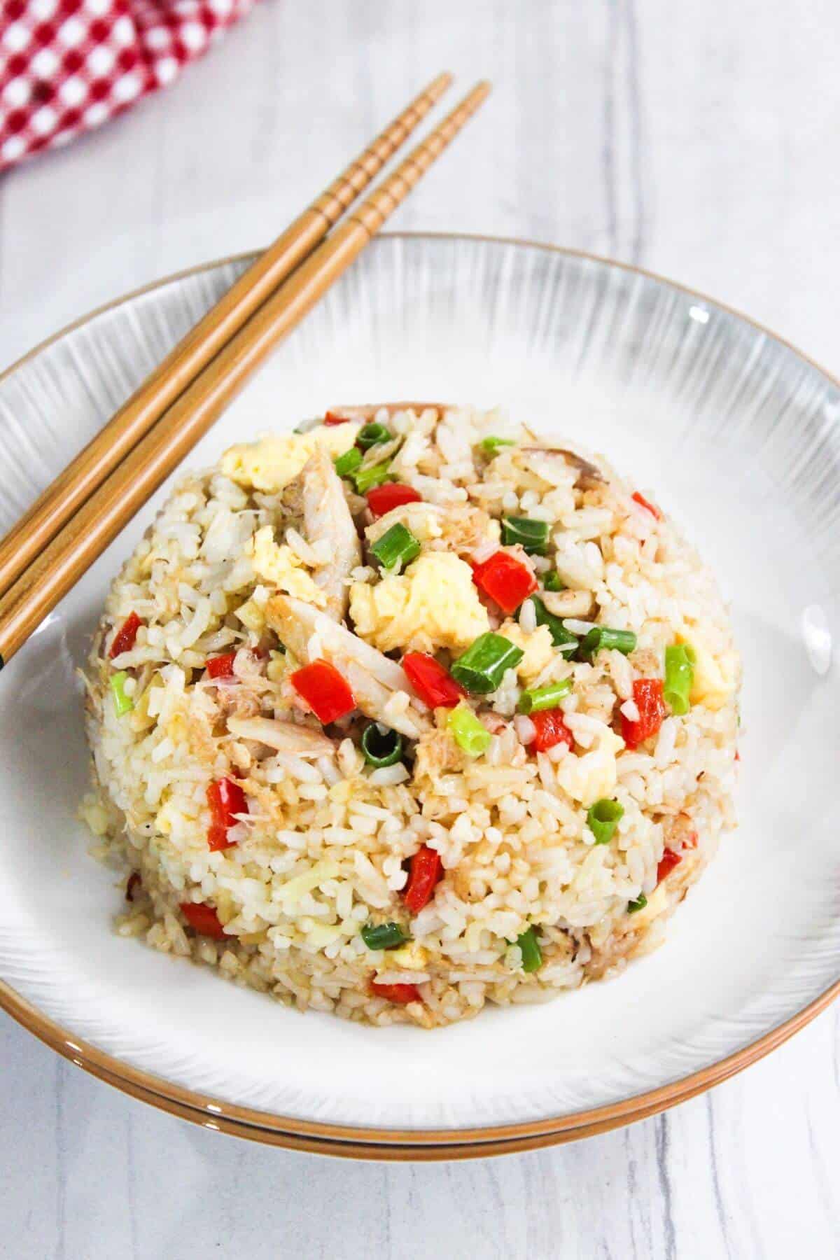 Crab fried rice on a plate with chopsticks.