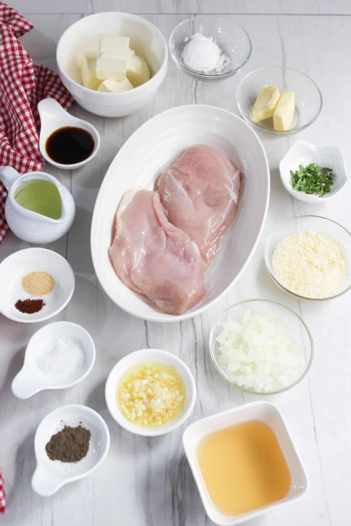 The ingredients for a chicken dish are laid out on a table.