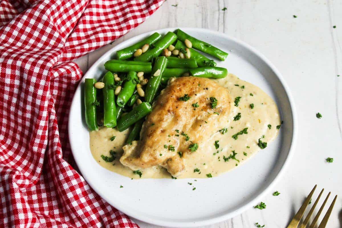 A plate with chicken and green beans on it.