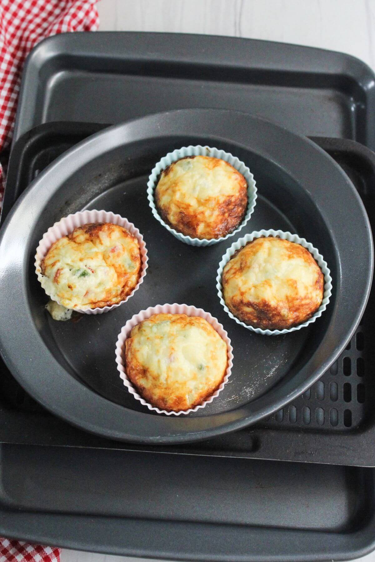 A group of egg white frittata muffins in a pan on air fryer tray.