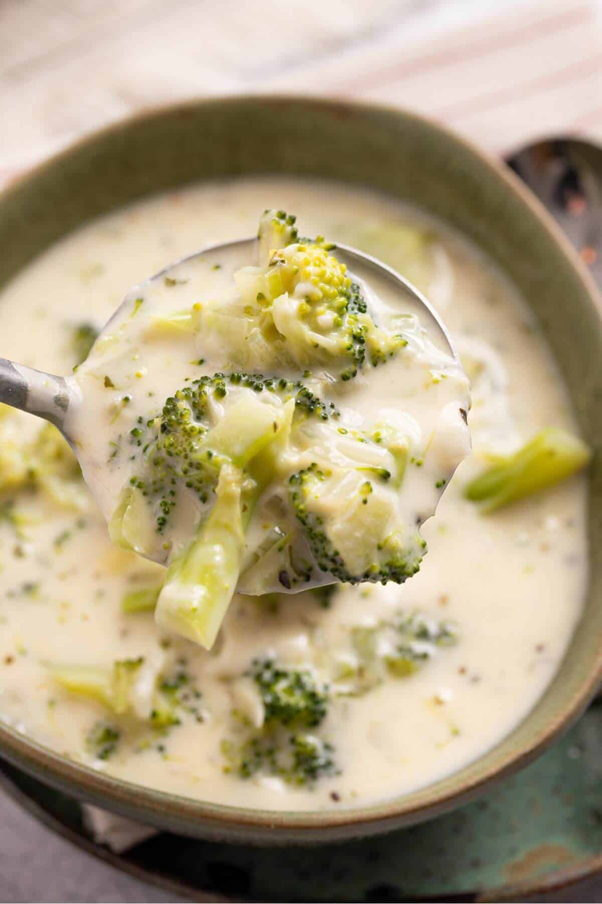 A bowl of broccoli soup with a spoon.