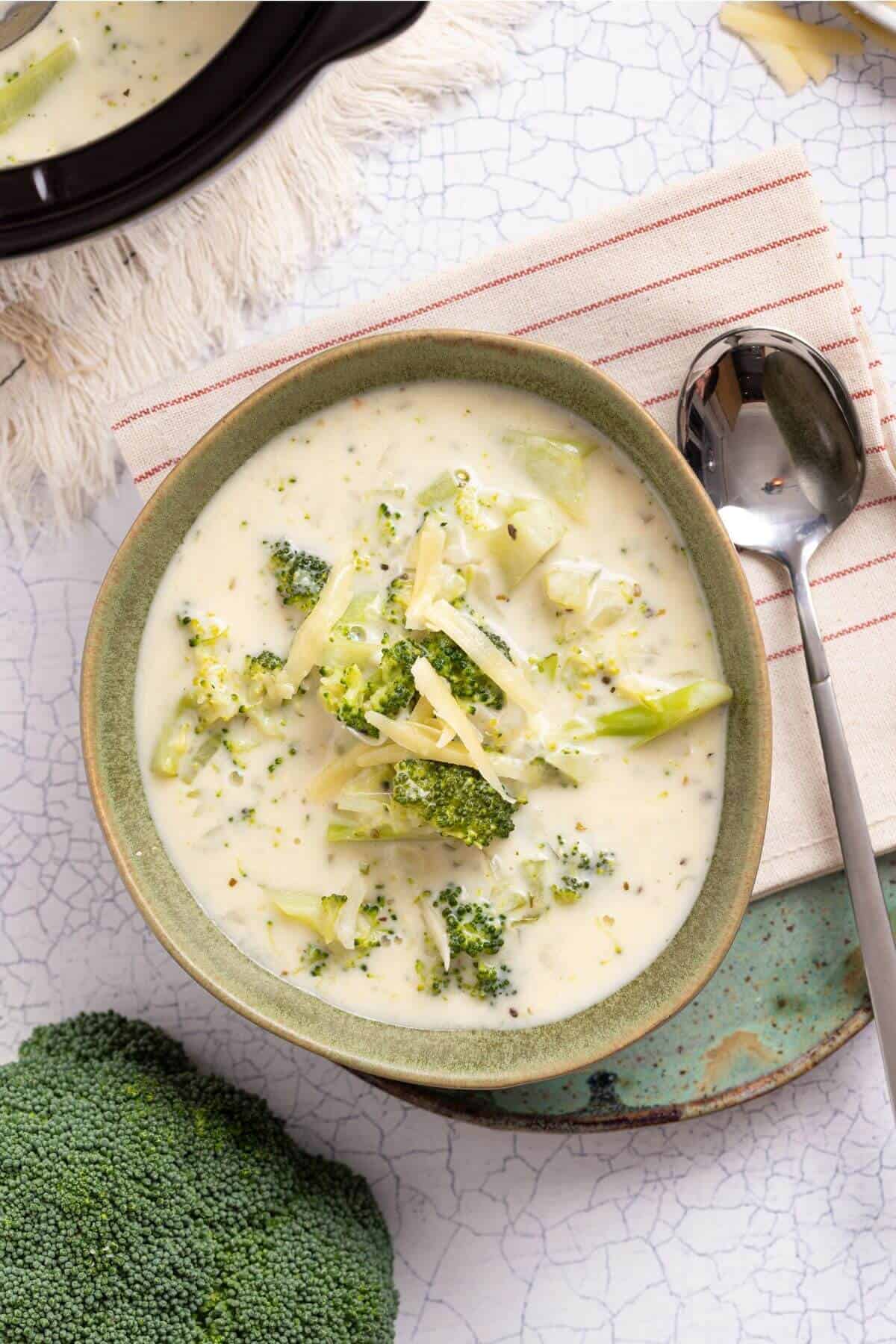 A bowl of broccoli soup with a spoon next to it.