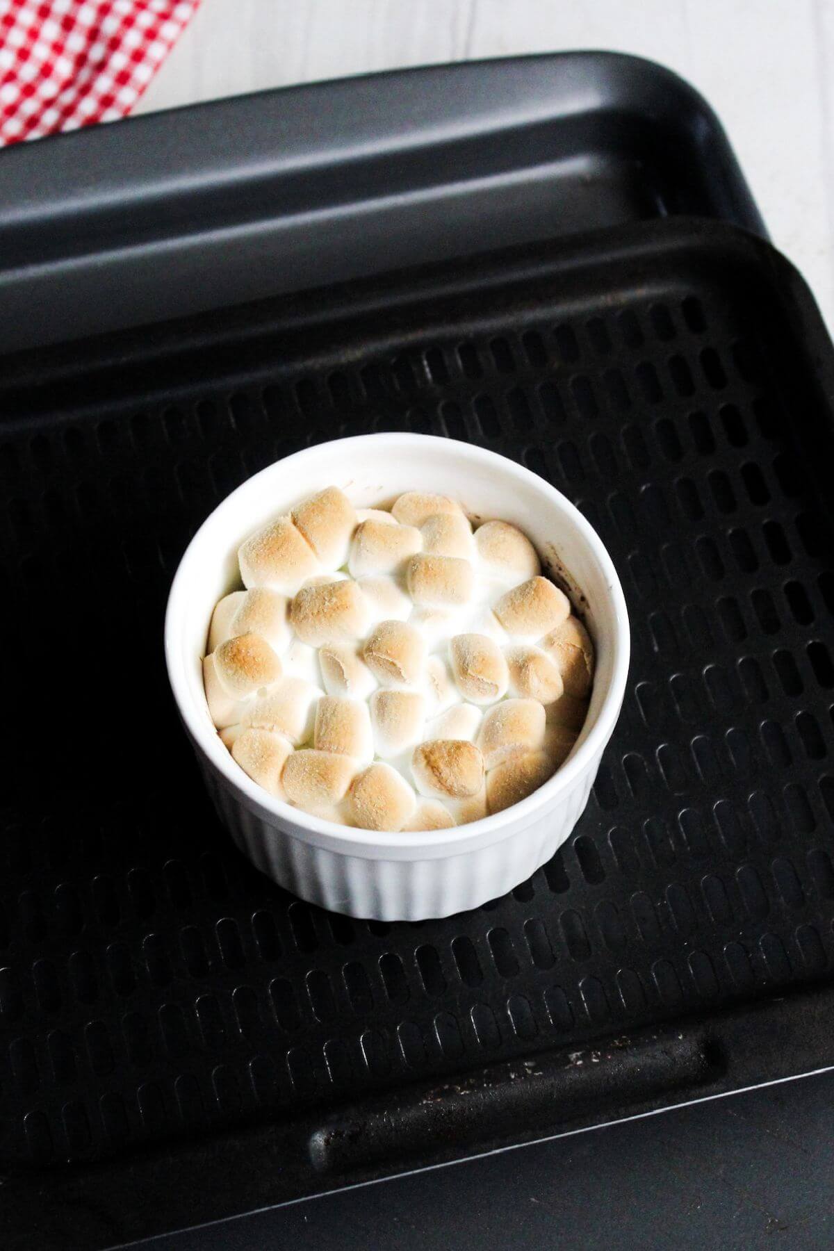 A bowl of s'mores dip sitting on top of an air fryer tray.