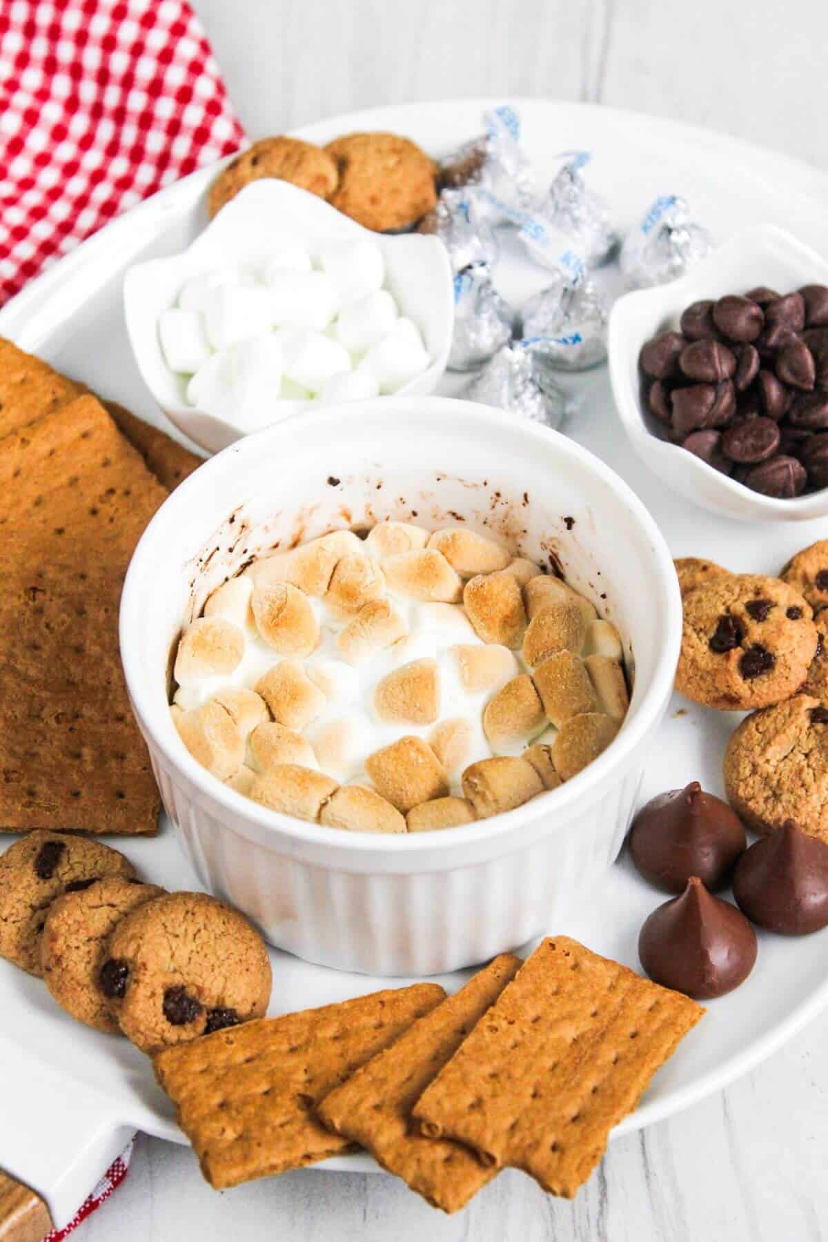S'mores dip on a plate with cookies and crackers.