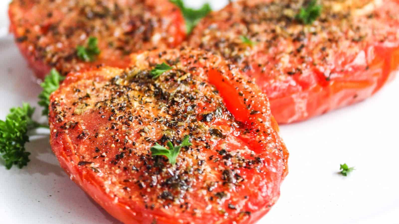 Roasted tomato halves seasoned with herbs and spices, garnished with parsley.