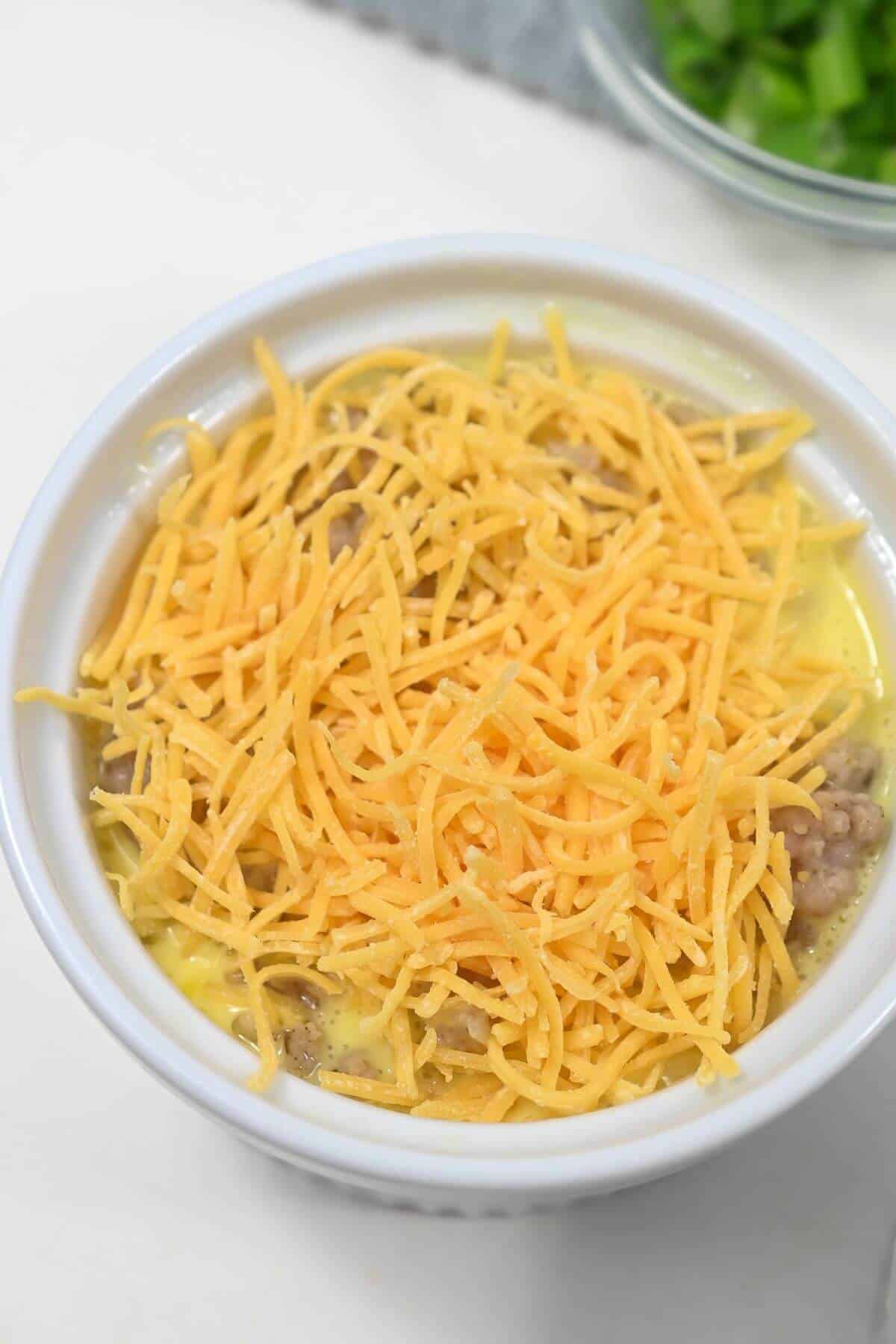 A biscuit breakfast casserole topped with shredded cheddar cheese.
